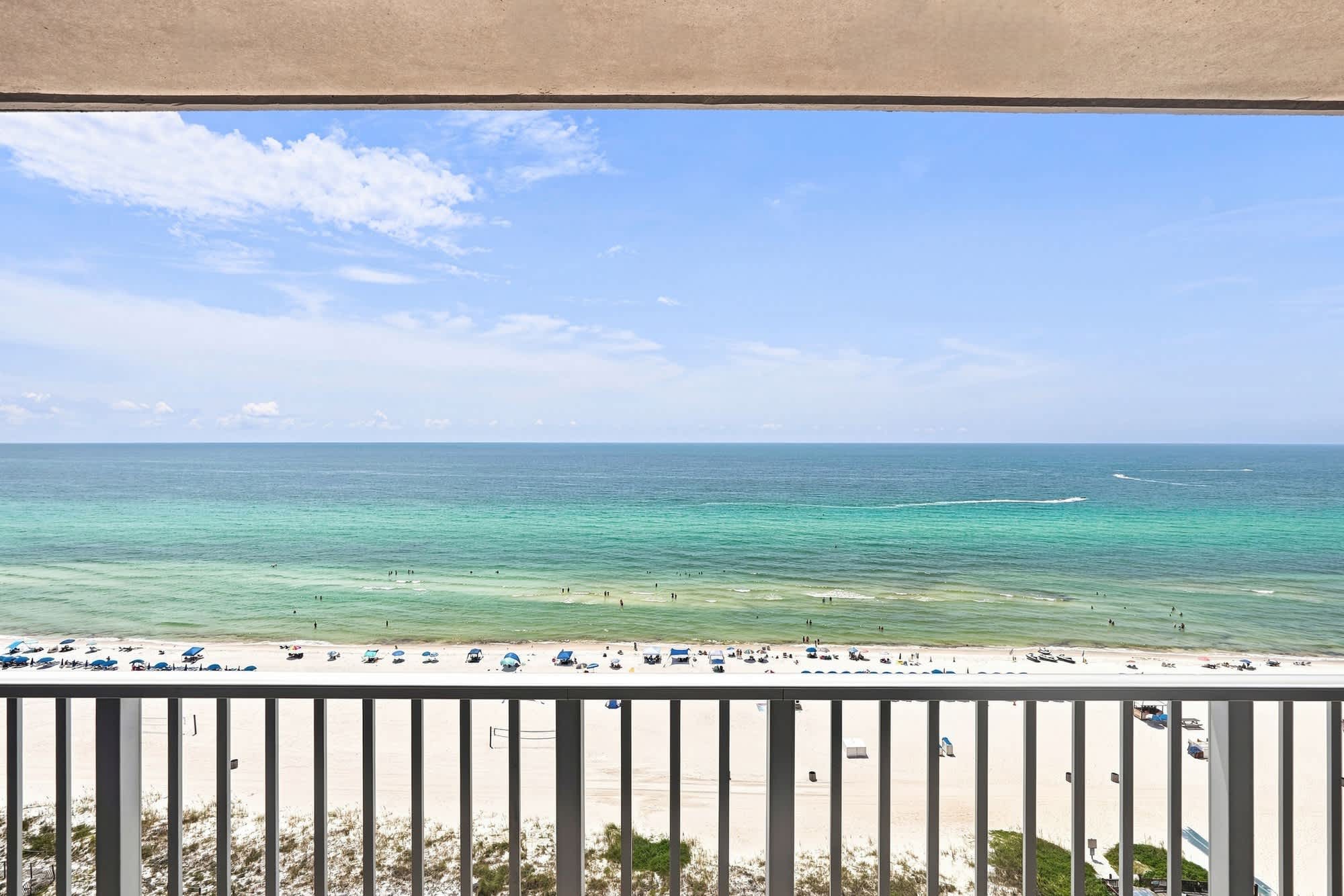 The Summit 1512 – Ocean view from balcony with white sandy beach and umbrellas in the foreground.