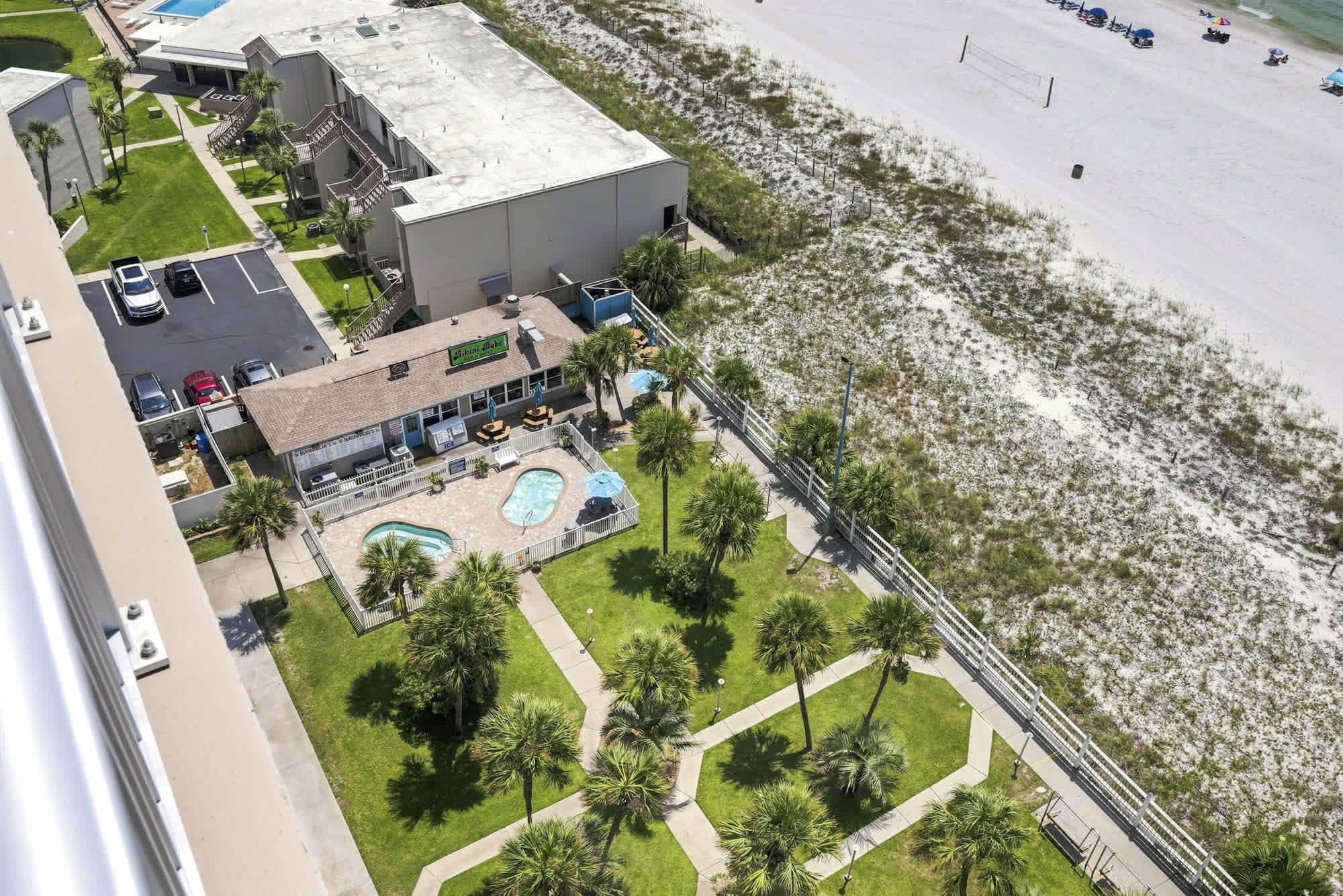 The Summit 1512 – Aerial view of a pool, palm trees, and nearby beach access at The Summit 1512.