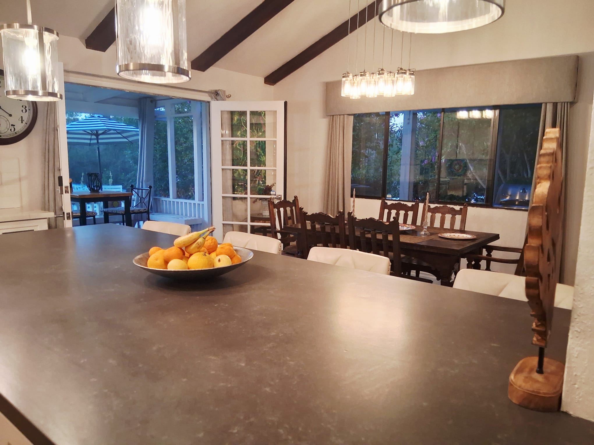 View of dining room and doors leading to enclosed sunroom patio from the kitchen