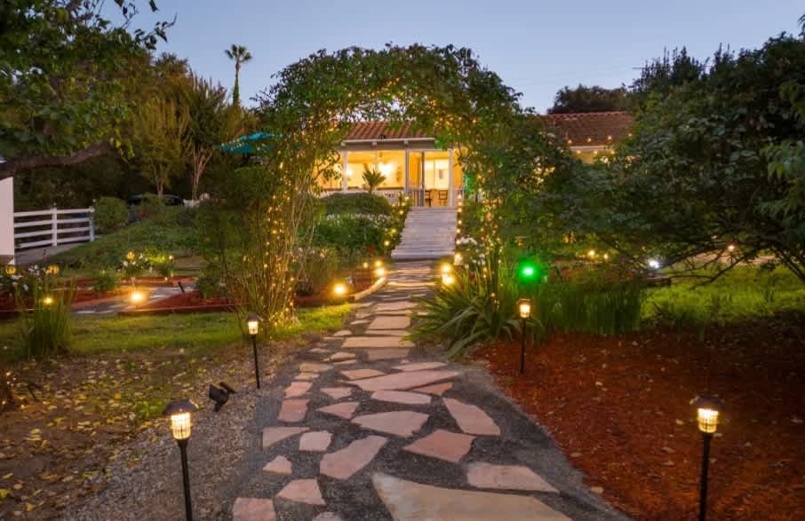 Pathway leading from backyard of property up to enclosed sunroom patio connected to the home.