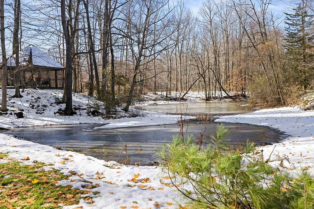 Berrywood Farm’s private pond offers a peaceful winter view surrounded by snow-covered woods.