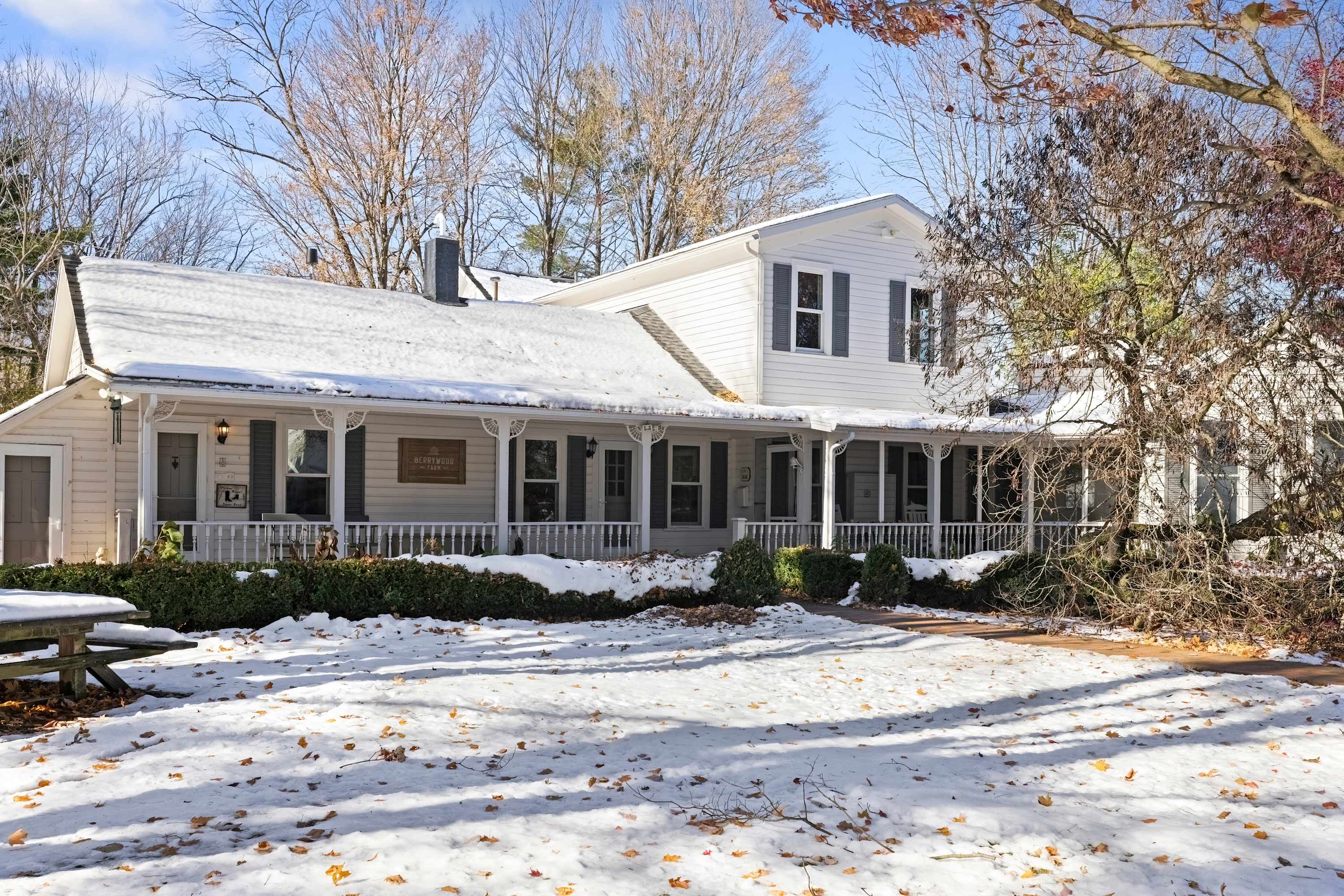 Berrywood Farmhouse exterior with a spacious two-story layout surrounded by wooded grounds.