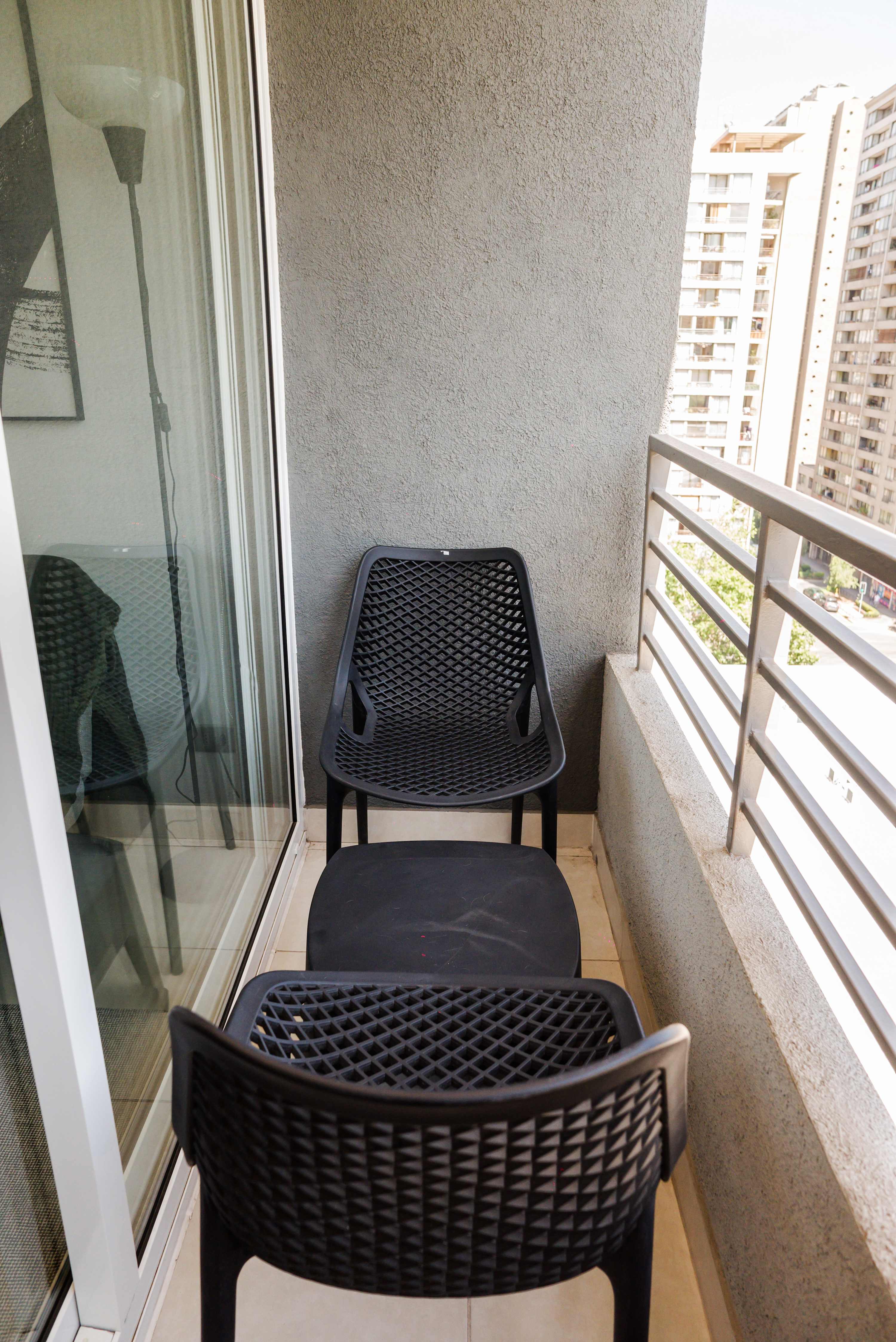 Private balcony with a city outlook, sliding glass doors, and a comfortable chair for enjoying fresh air.