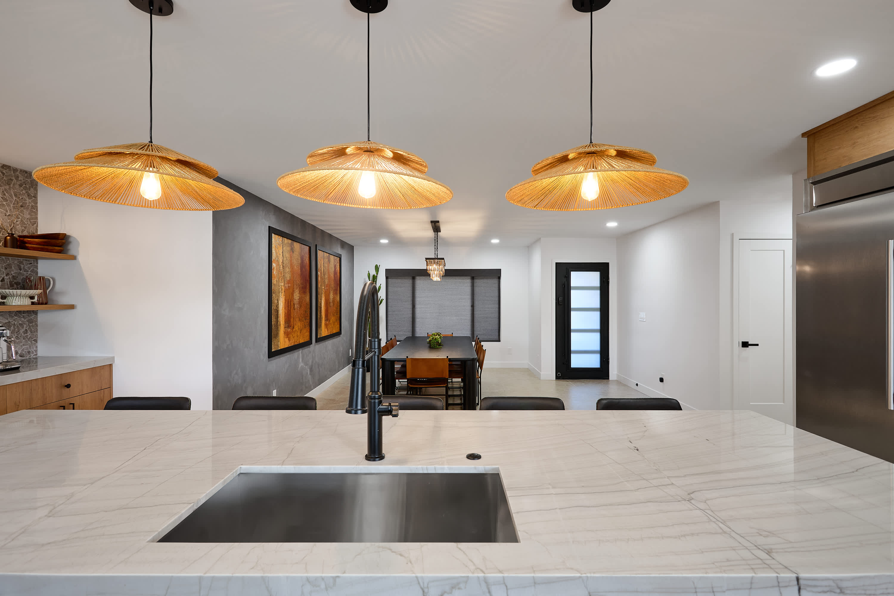Sleek open concept kitchen with stainless steel appliances, large island with breakfast bar seating for 5, coffee bar with espresso machine, and fully equipped with your basic cooking essentials.
