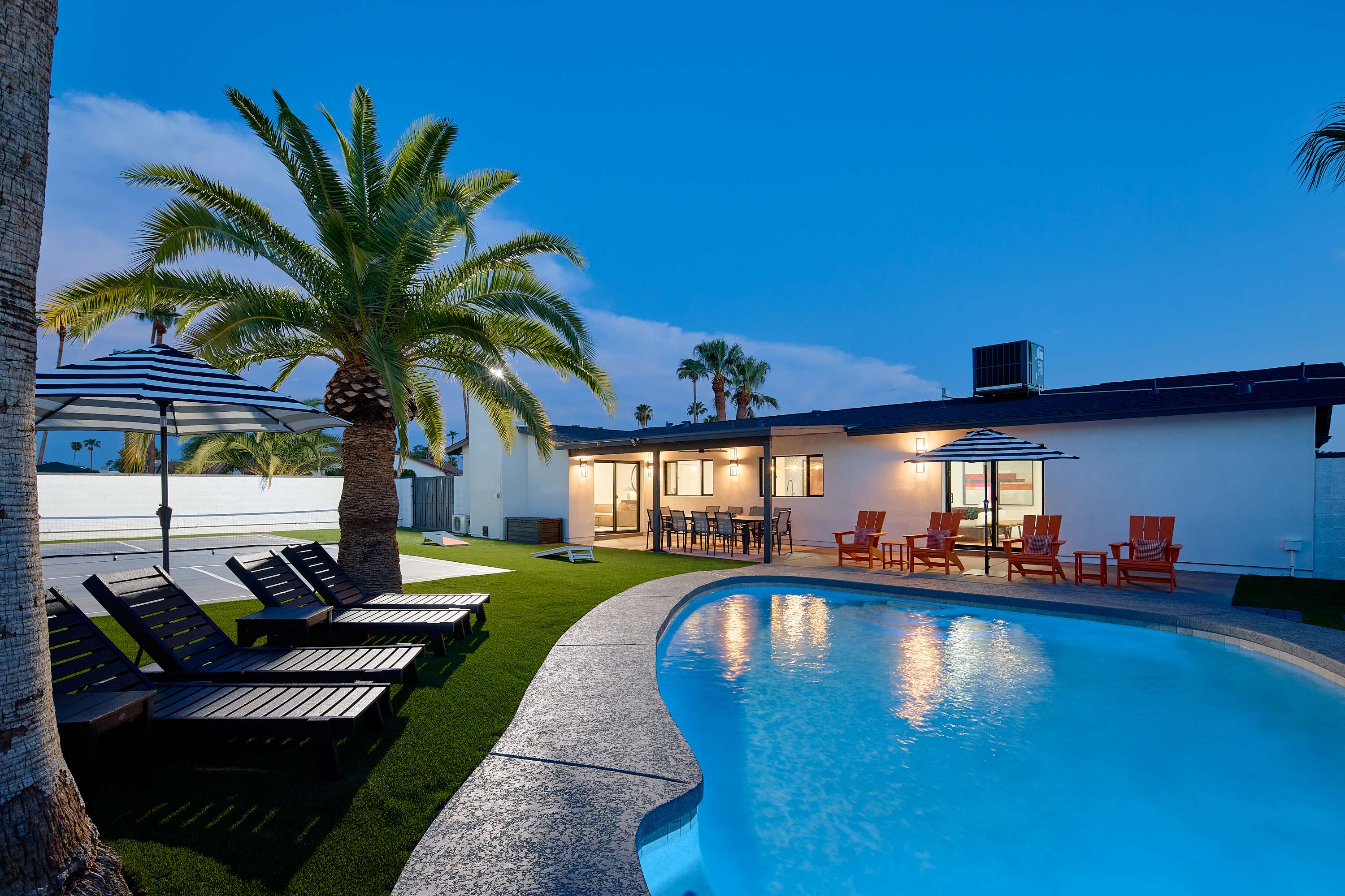 Private pool surrounded by poolside loungers, umbrellas, and multiple shaded seating areas.