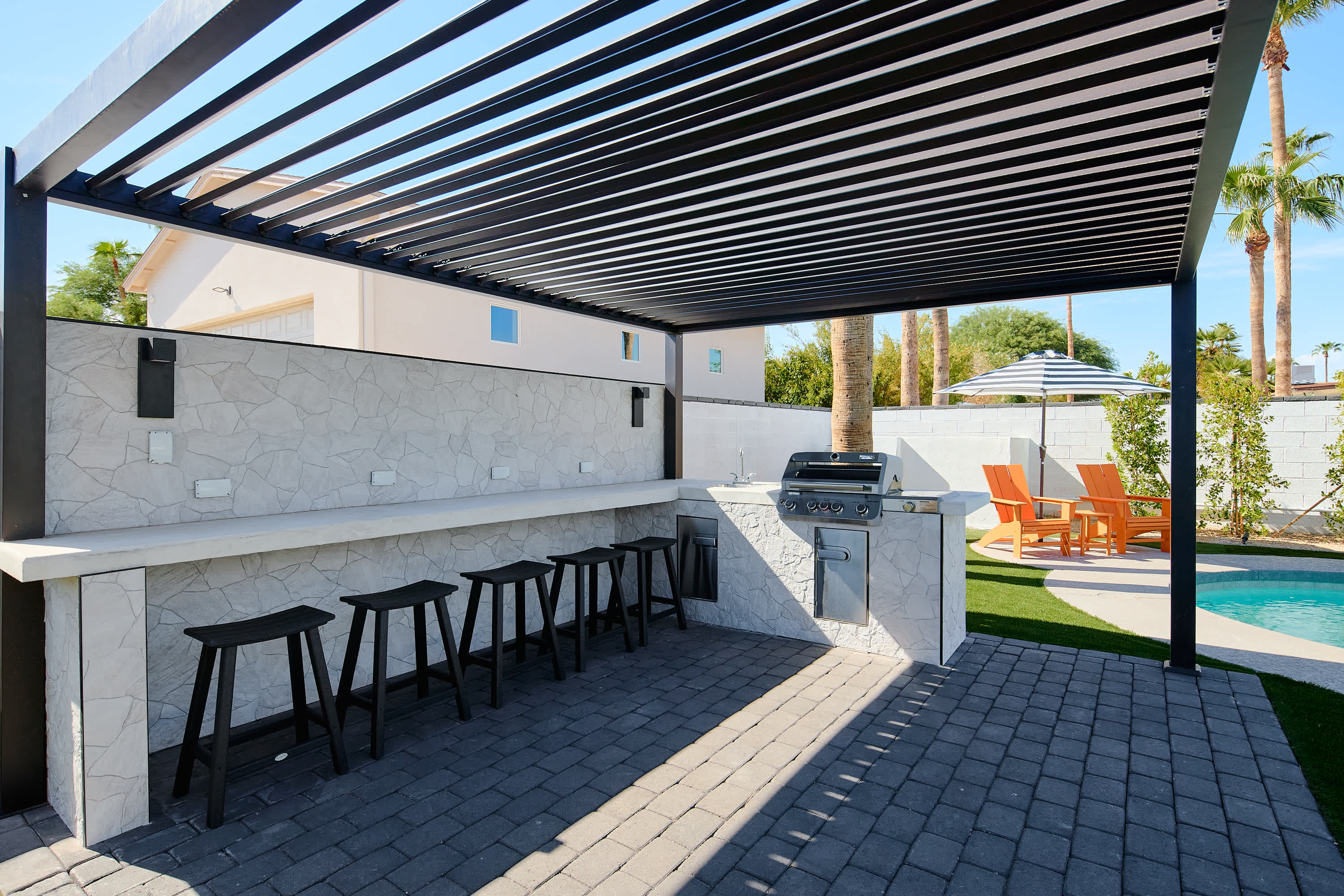 Poolside pergola with built in BBQ & bar seating for 6.