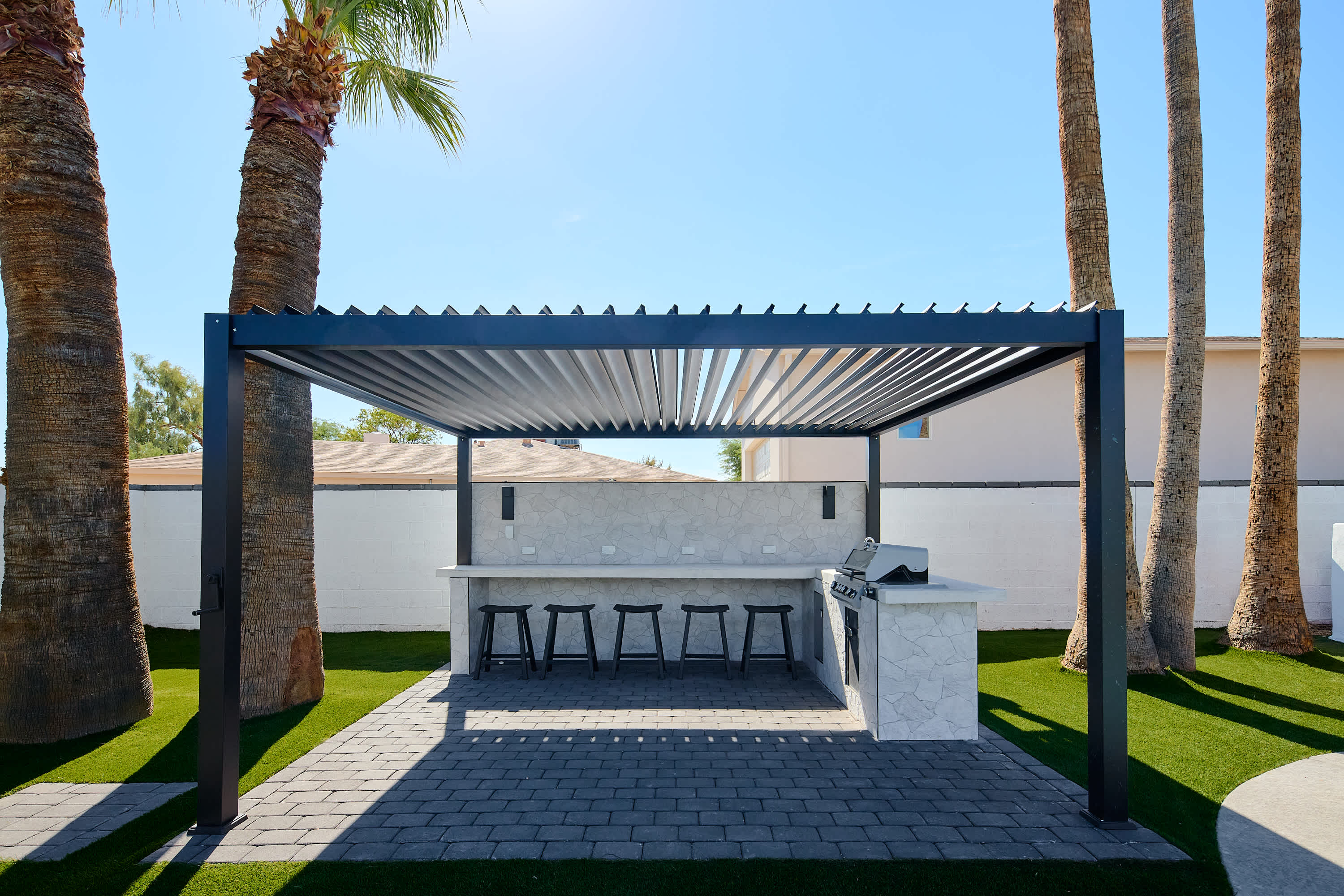 Poolside pergola with built in BBQ & bar seating for 6.