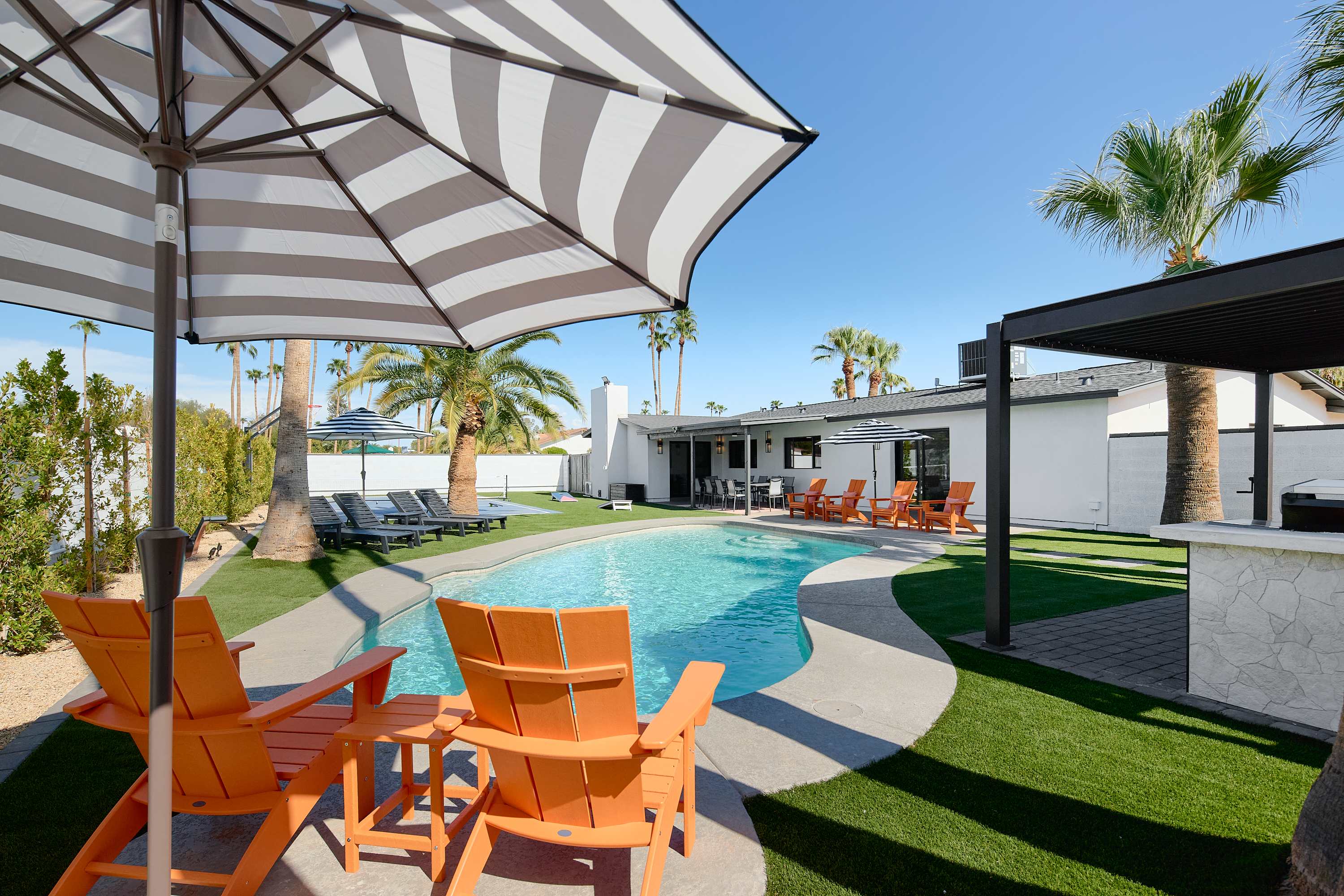 Private pool surrounded by poolside loungers, umbrellas, and multiple shaded seating areas.