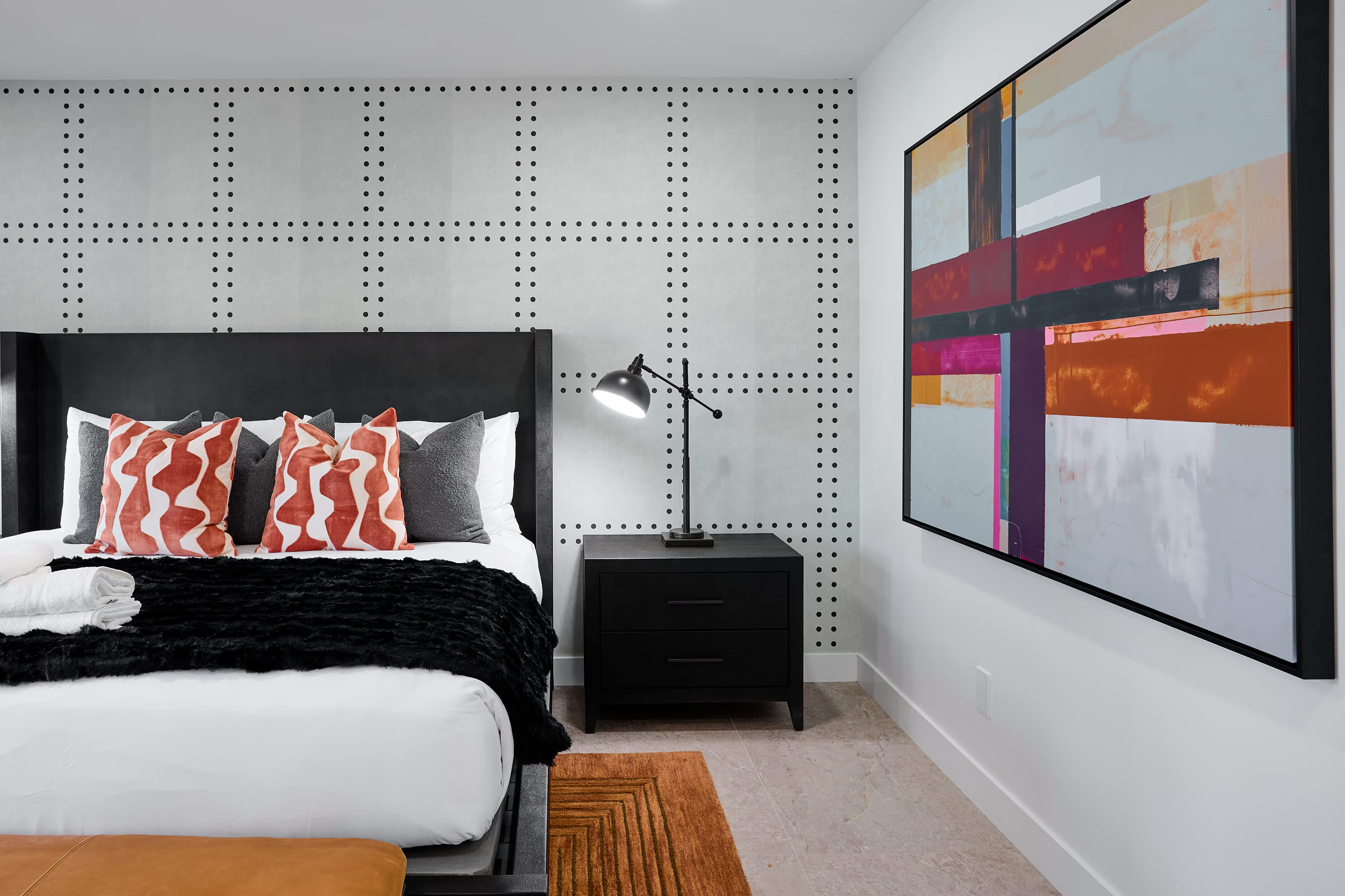 Primary bedroom with King bed, designer furnishings, walk-in closet, smart TV, ceiling fan, direct access to backyard, work station, and en-suite bathroom.