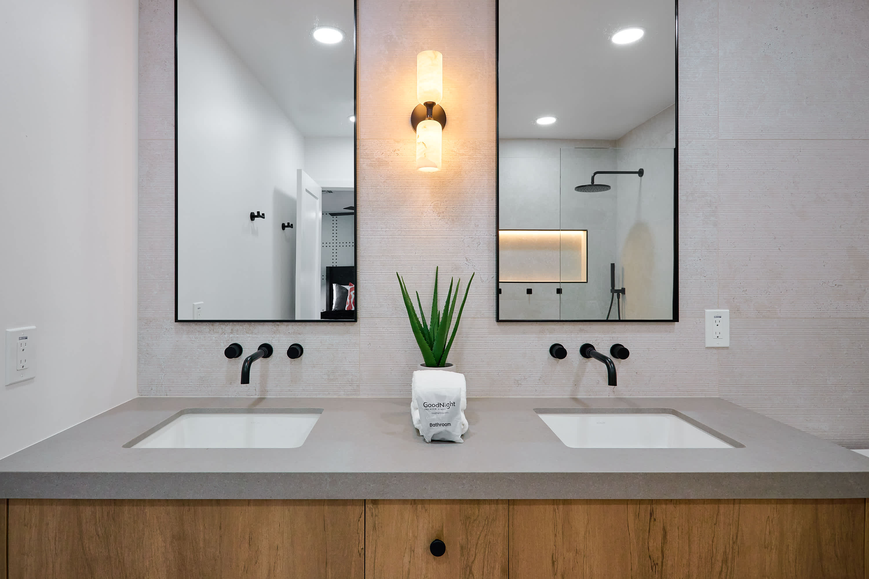 Primary bathroom with dual vanity sinks, and walk-in shower with LED shelf lighting.