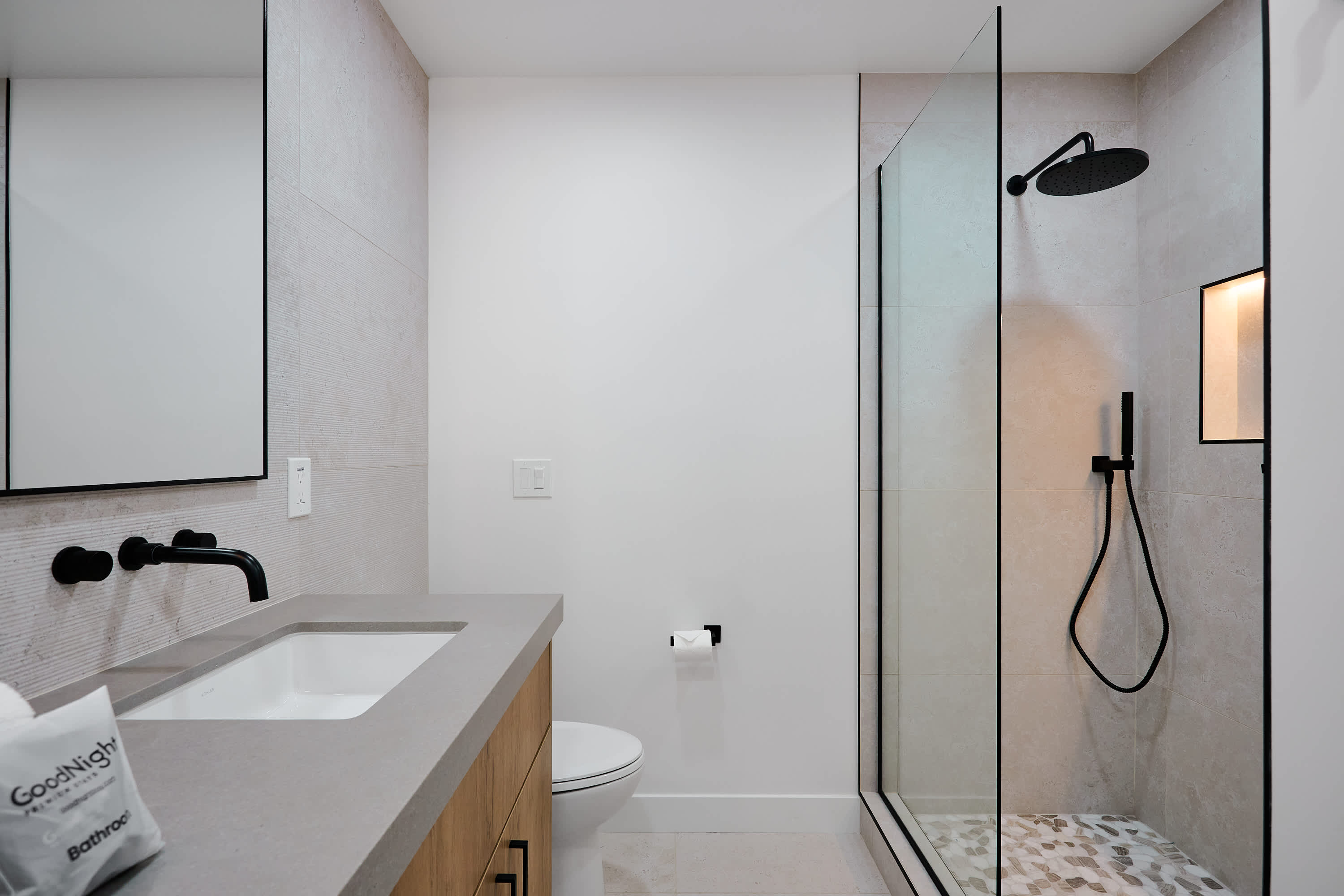 Primary bathroom with dual vanity sinks, and walk-in shower with LED shelf lighting.