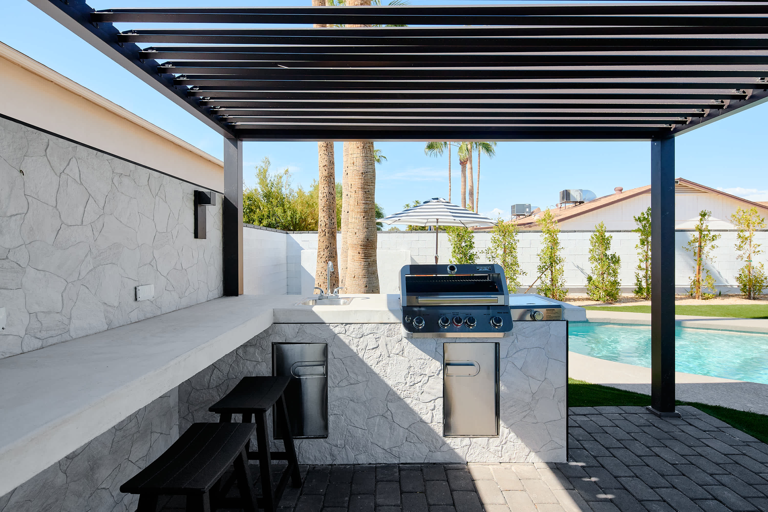 Poolside pergola with built in BBQ & bar seating for 6.