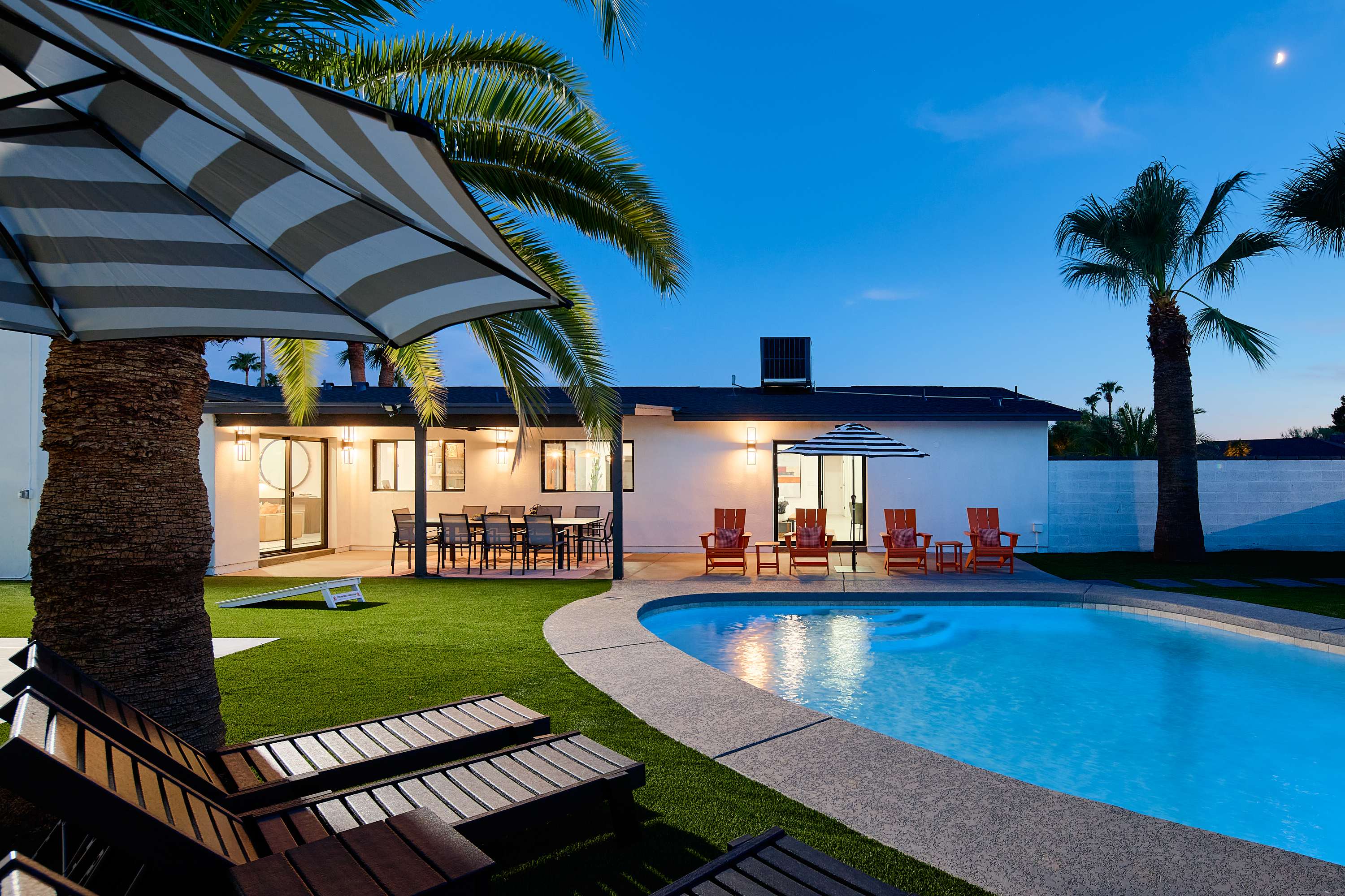 Private pool surrounded by poolside loungers, umbrellas, and multiple shaded seating areas.