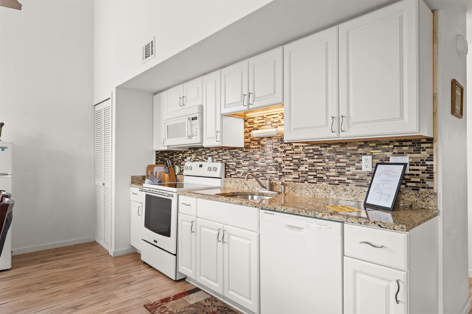 The sleek, efficient kitchen offers ample space & all the comforts of home