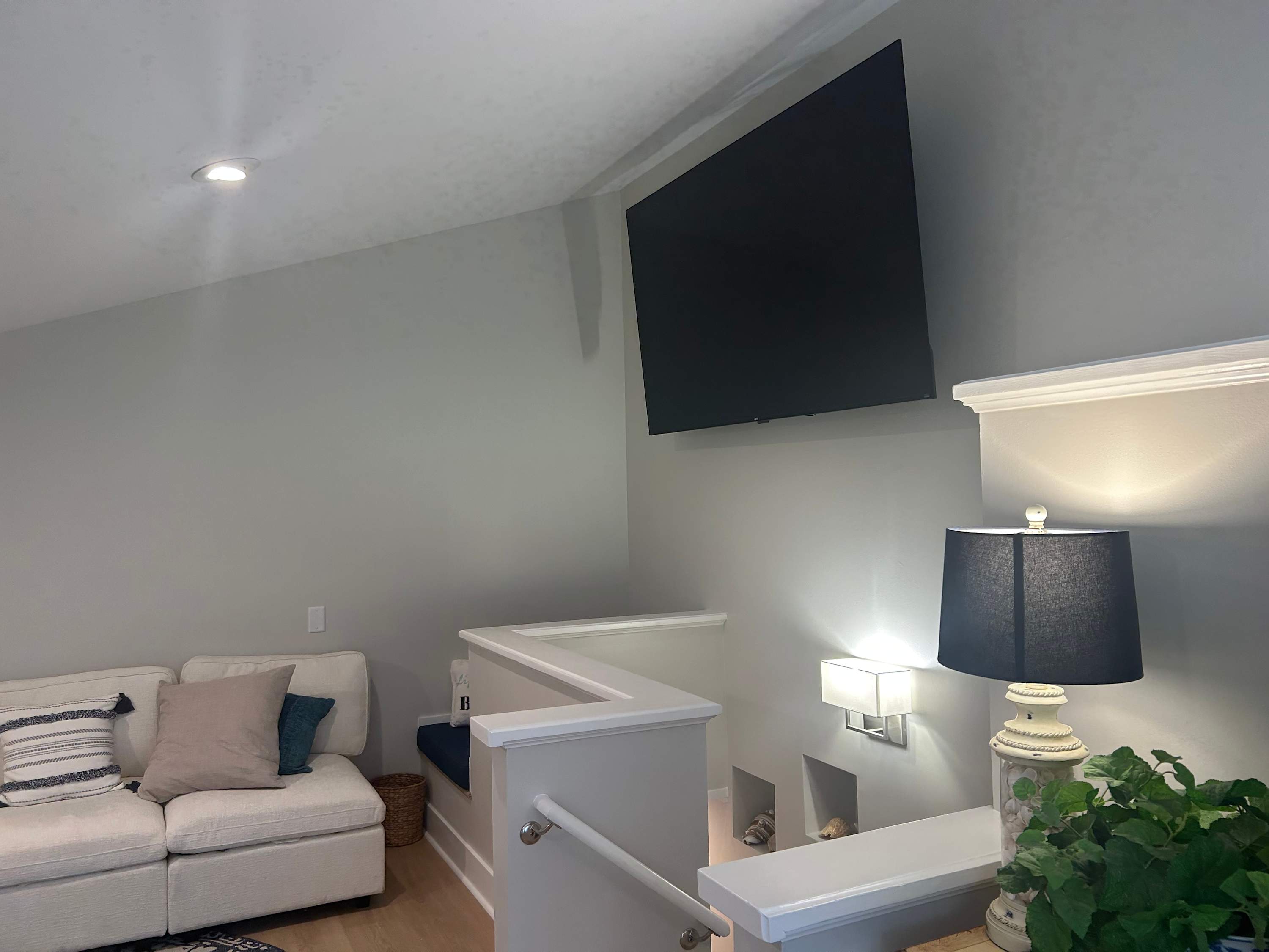 1st level den with sectional couch, table and chairs and tv.Stairs lead to ground level