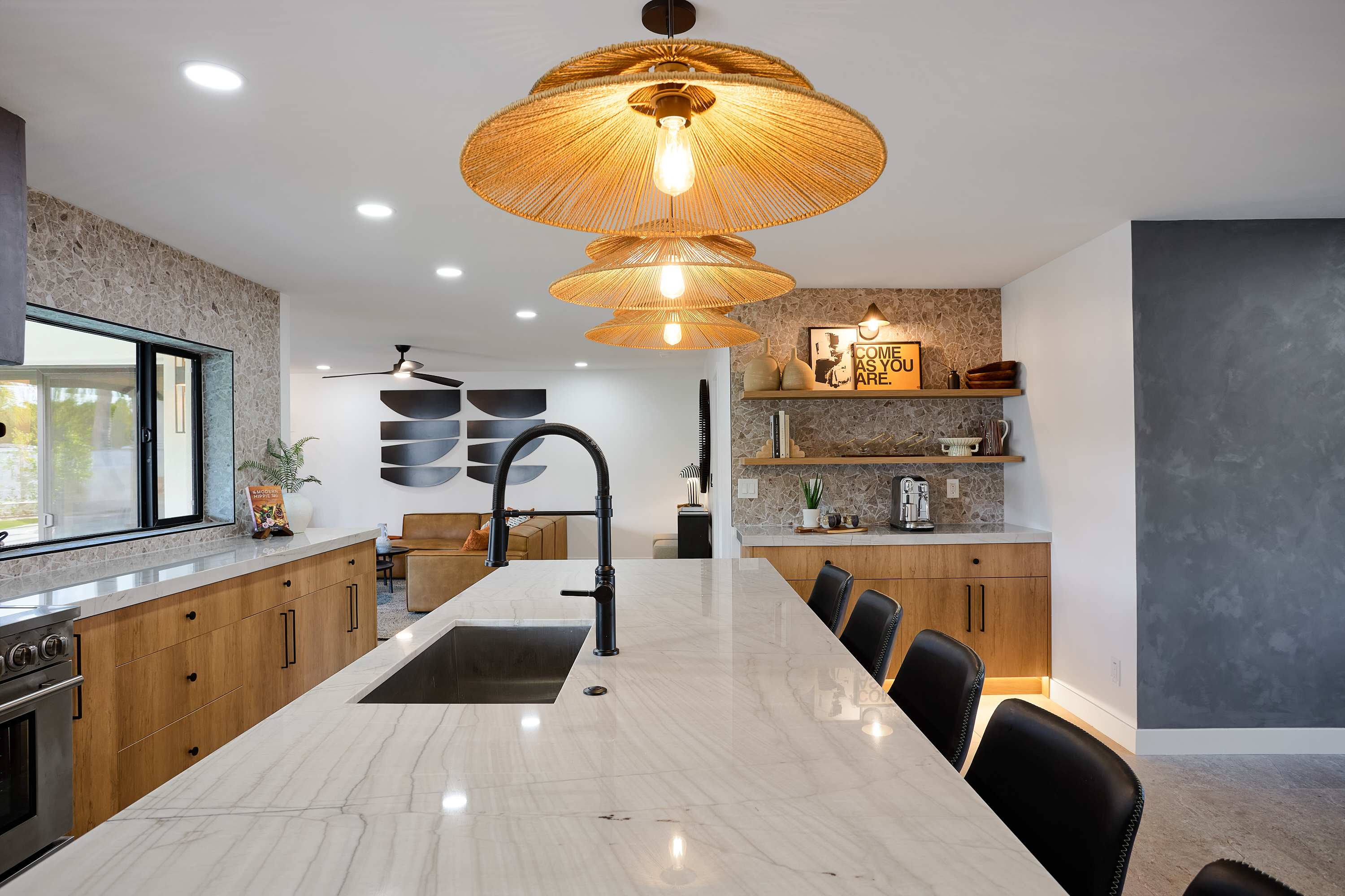 Sleek open concept kitchen with stainless steel appliances, large island with breakfast bar seating for 5, coffee bar with espresso machine, and fully equipped with your basic cooking essentials.