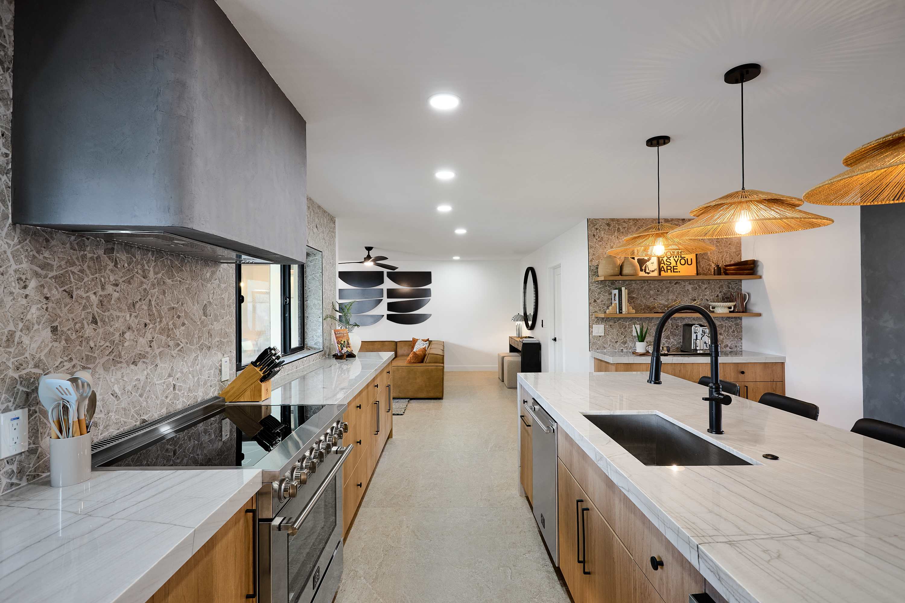 Sleek open concept kitchen with stainless steel appliances, large island with breakfast bar seating for 5, coffee bar with espresso machine, and fully equipped with your basic cooking essentials.