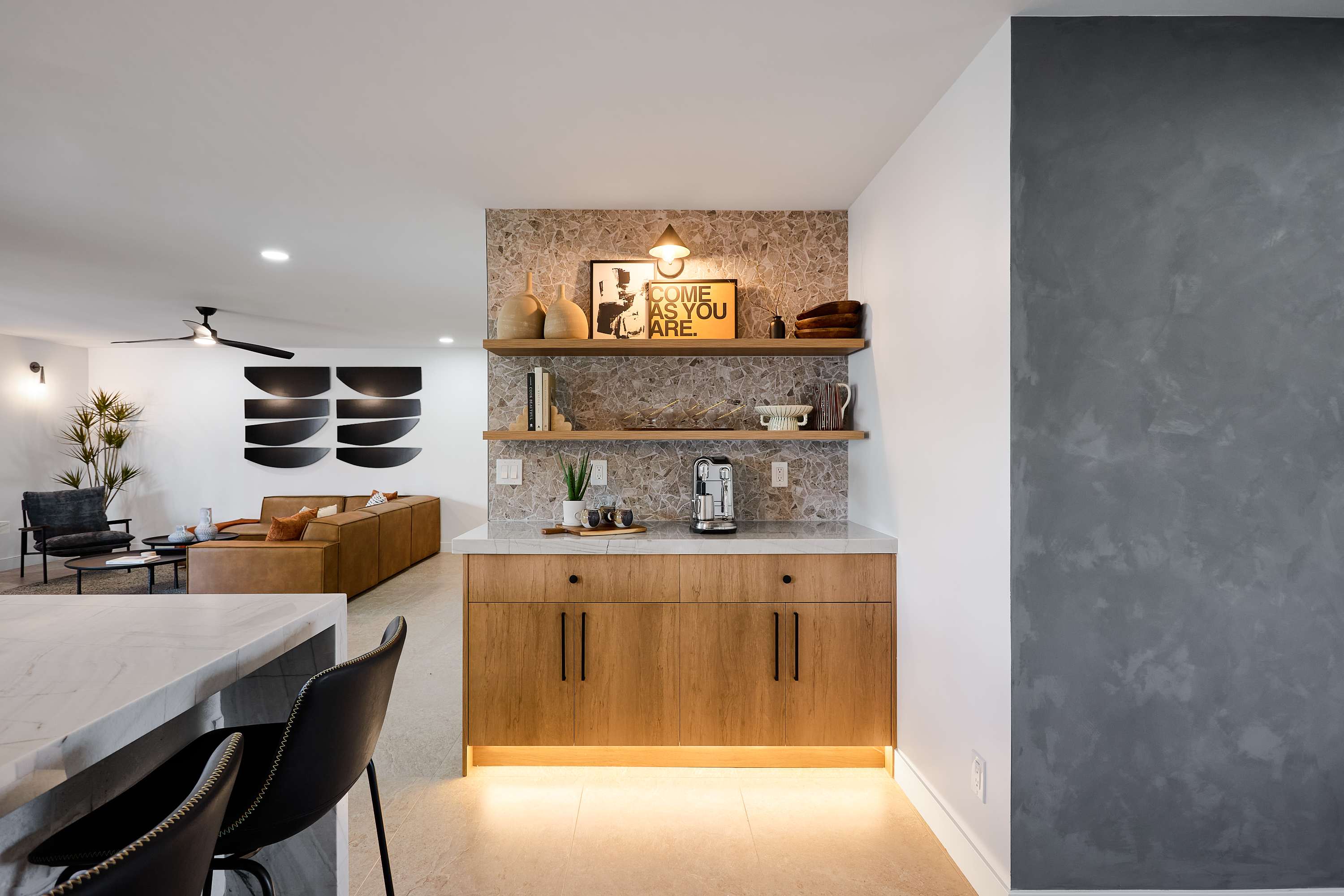 Sleek open concept kitchen with stainless steel appliances, large island with breakfast bar seating for 5, coffee bar with espresso machine, and fully equipped with your basic cooking essentials.