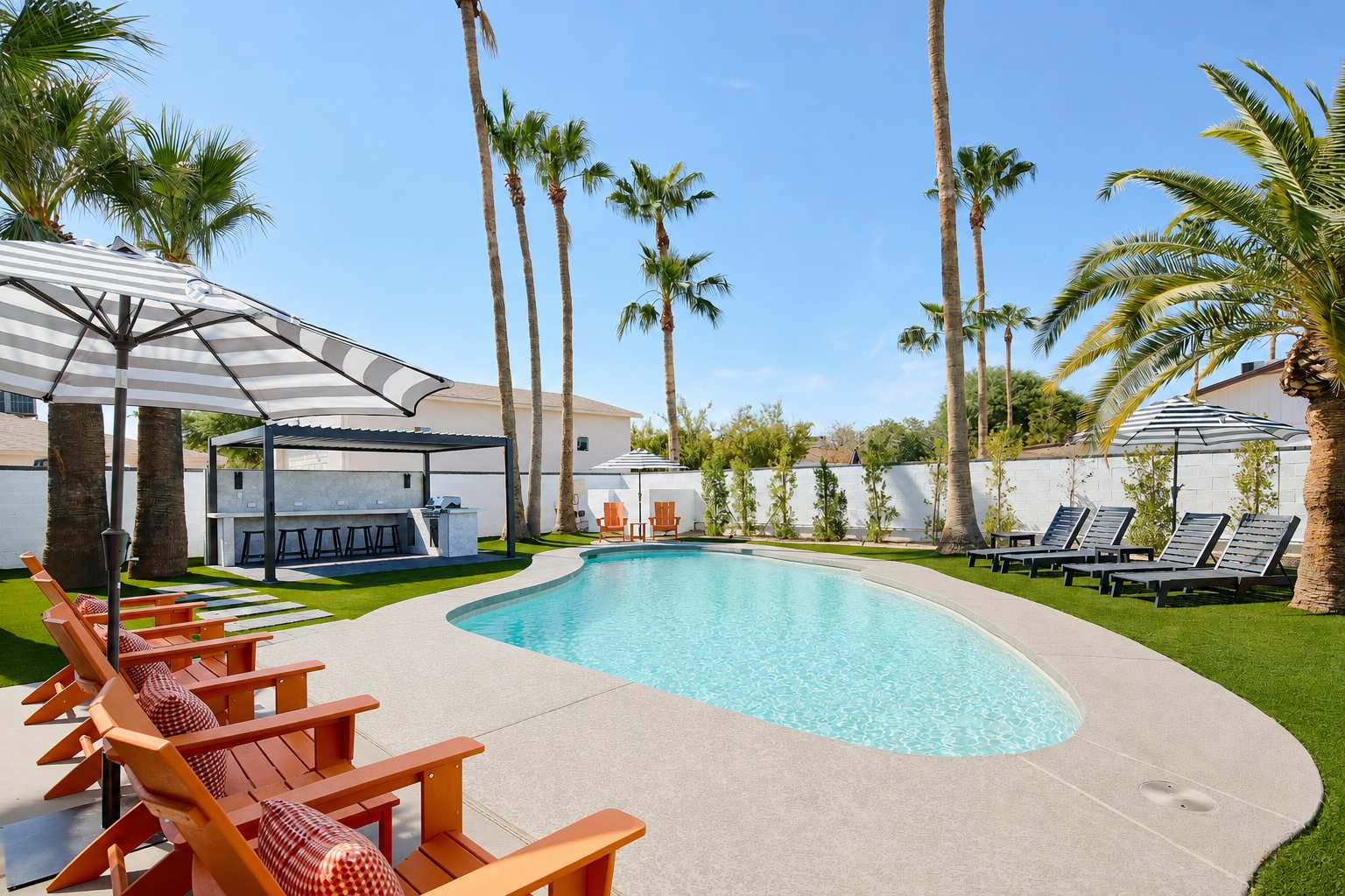 Private pool surrounded by poolside loungers, umbrellas, and multiple shaded seating areas.
