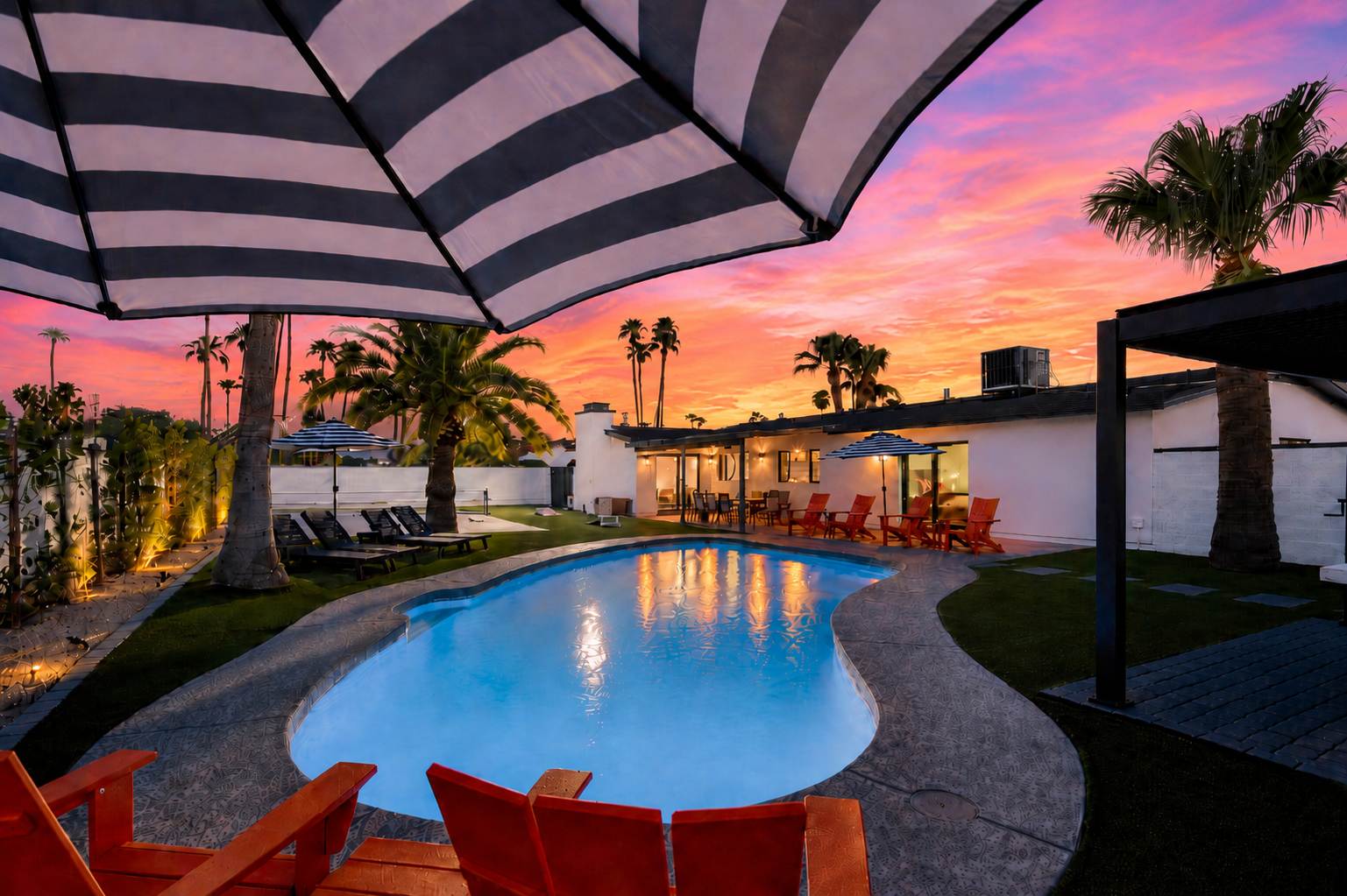 Private pool surrounded by poolside loungers, umbrellas, and multiple shaded seating areas.