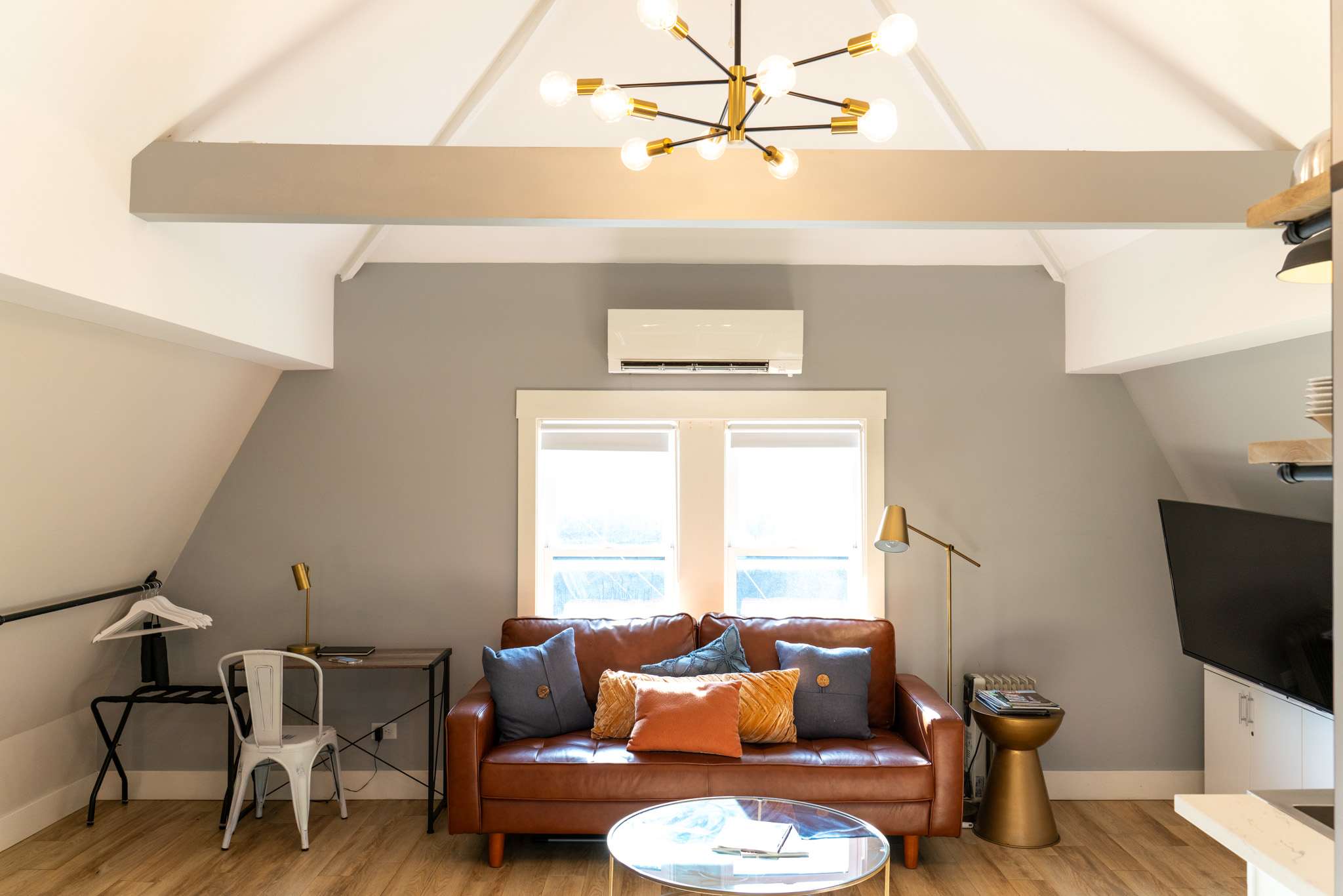 Vaulted ceilings and a sunlit sitting area give you room to relax, with a desk tucked neatly beside the sofa.