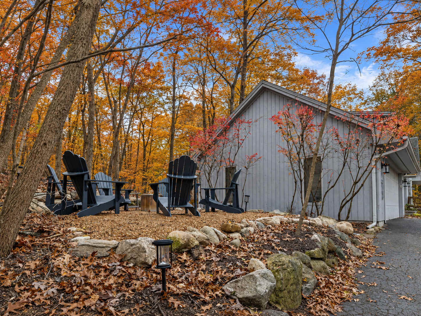 Wooded outdoor seating puts fall leaf peeping right outside the home.