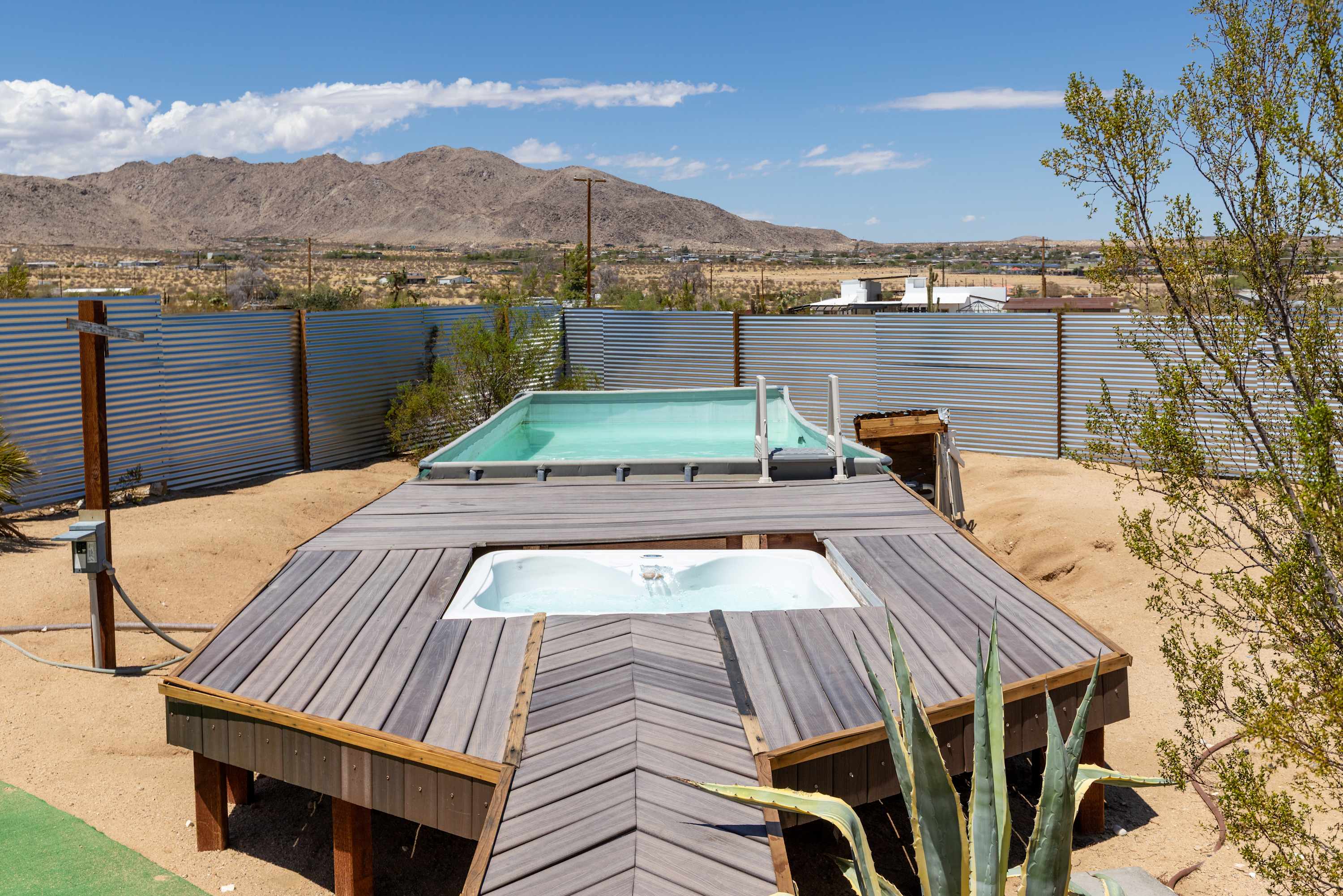 Studio rectangular pool and inset spa on the wood deck, framed by desert mountains.