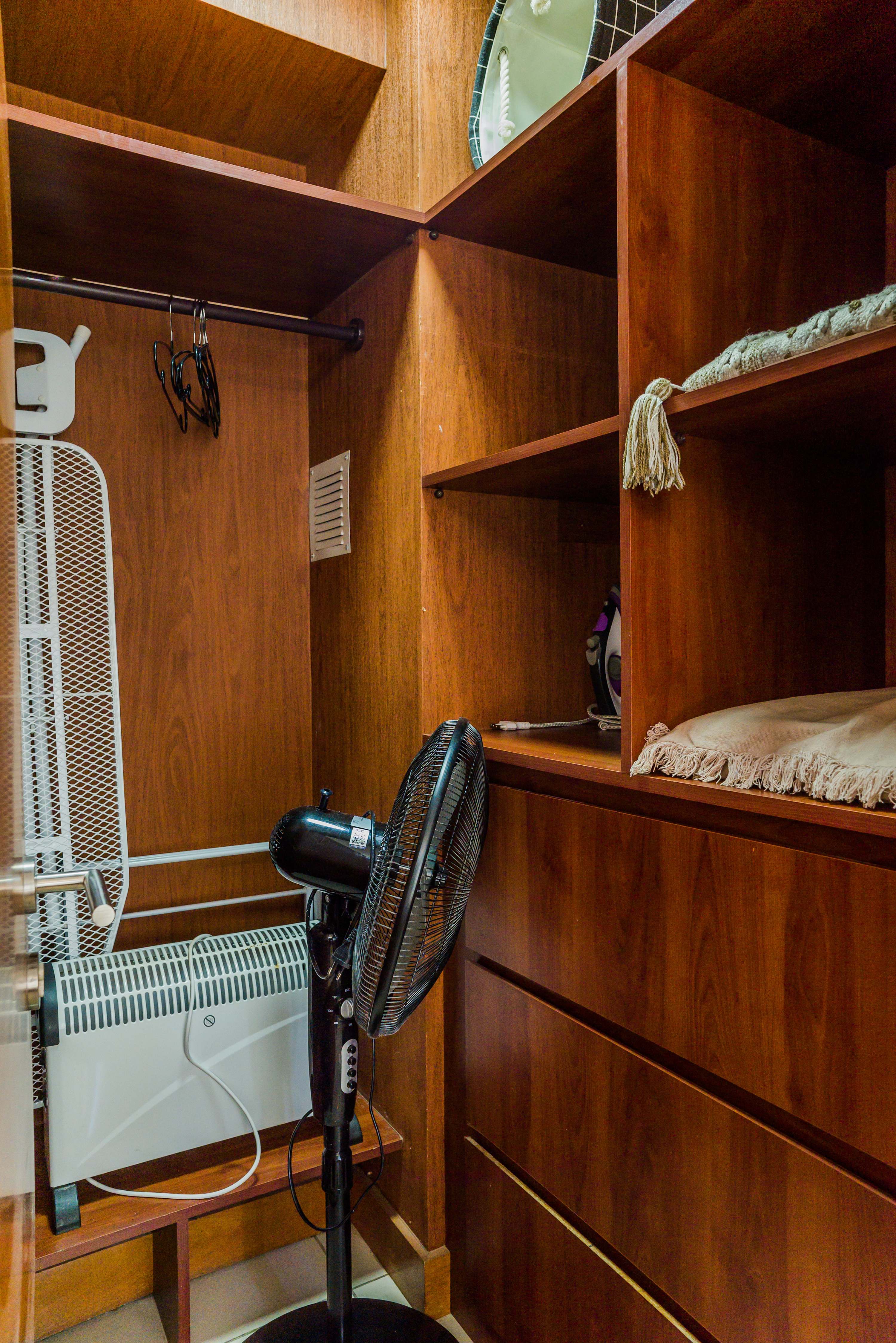 Compact laundry area with a drying rack and ironing board for convenient garment care during your stay.