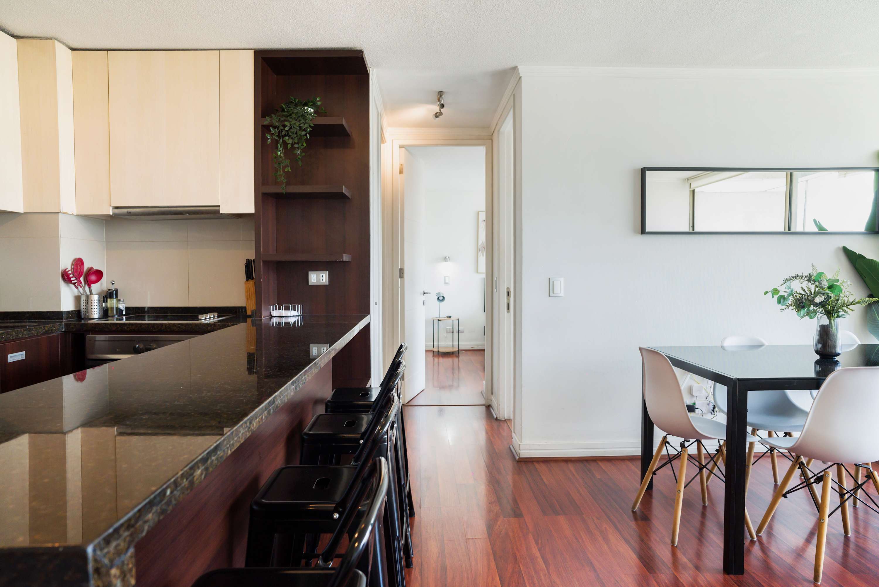 Private kitchen with a polished granite breakfast bar, black stools, and an adjacent dining table ready for shared meals.