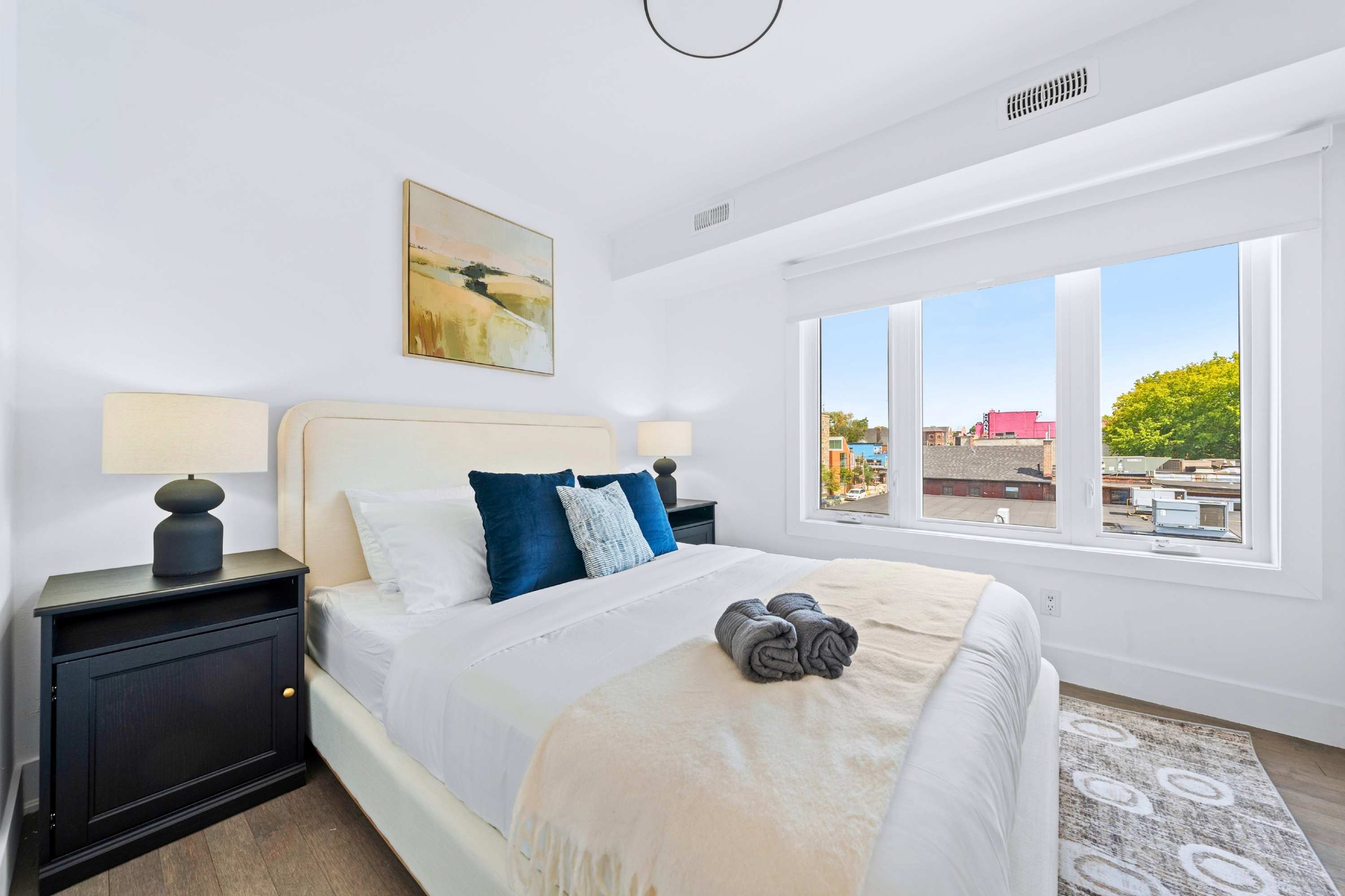 Primary suite featuring a plush queen mattress and large windows with soft ambient lighting.