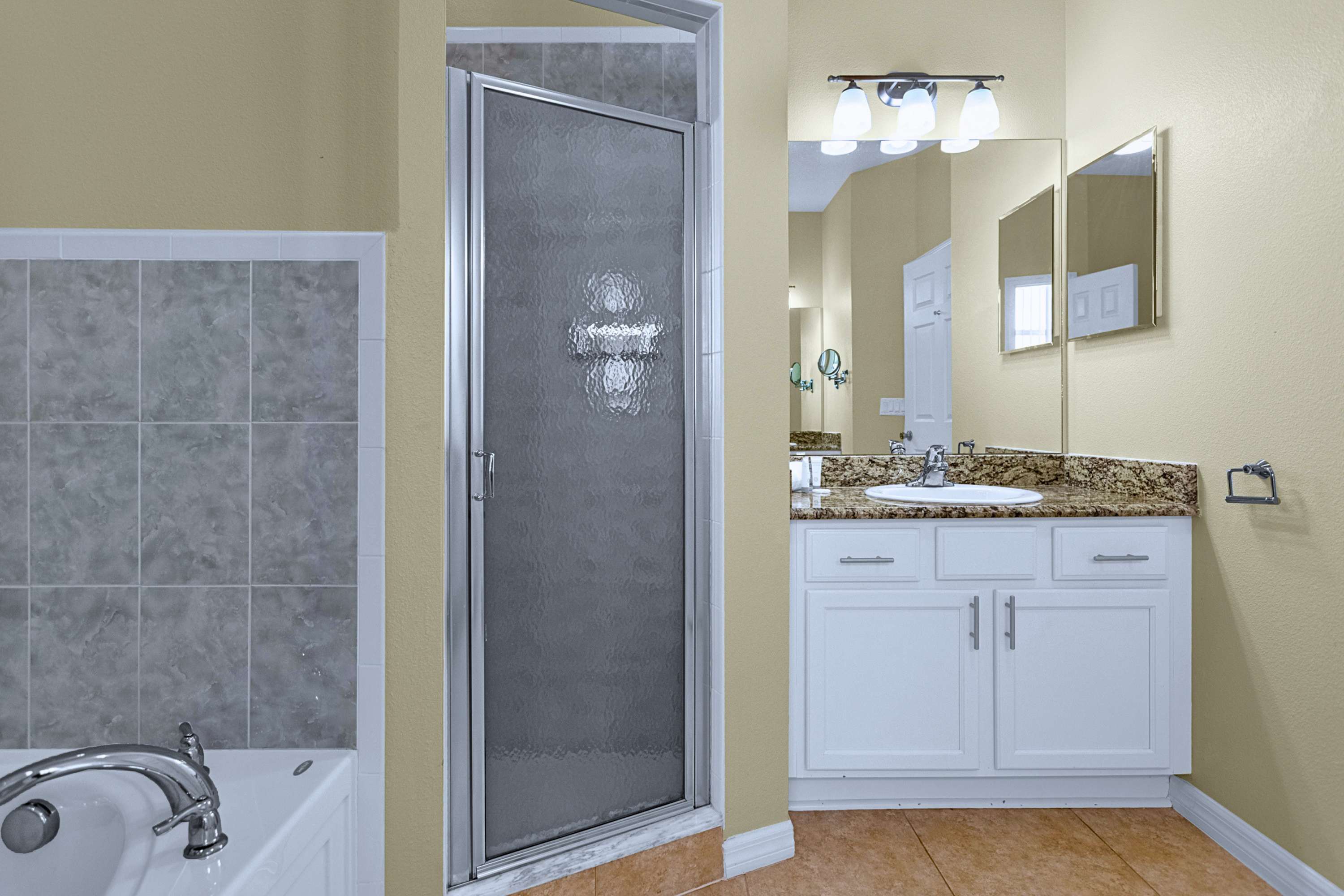 Refresh in style: ensuite bathroom featuring full tub, shower, and sink.