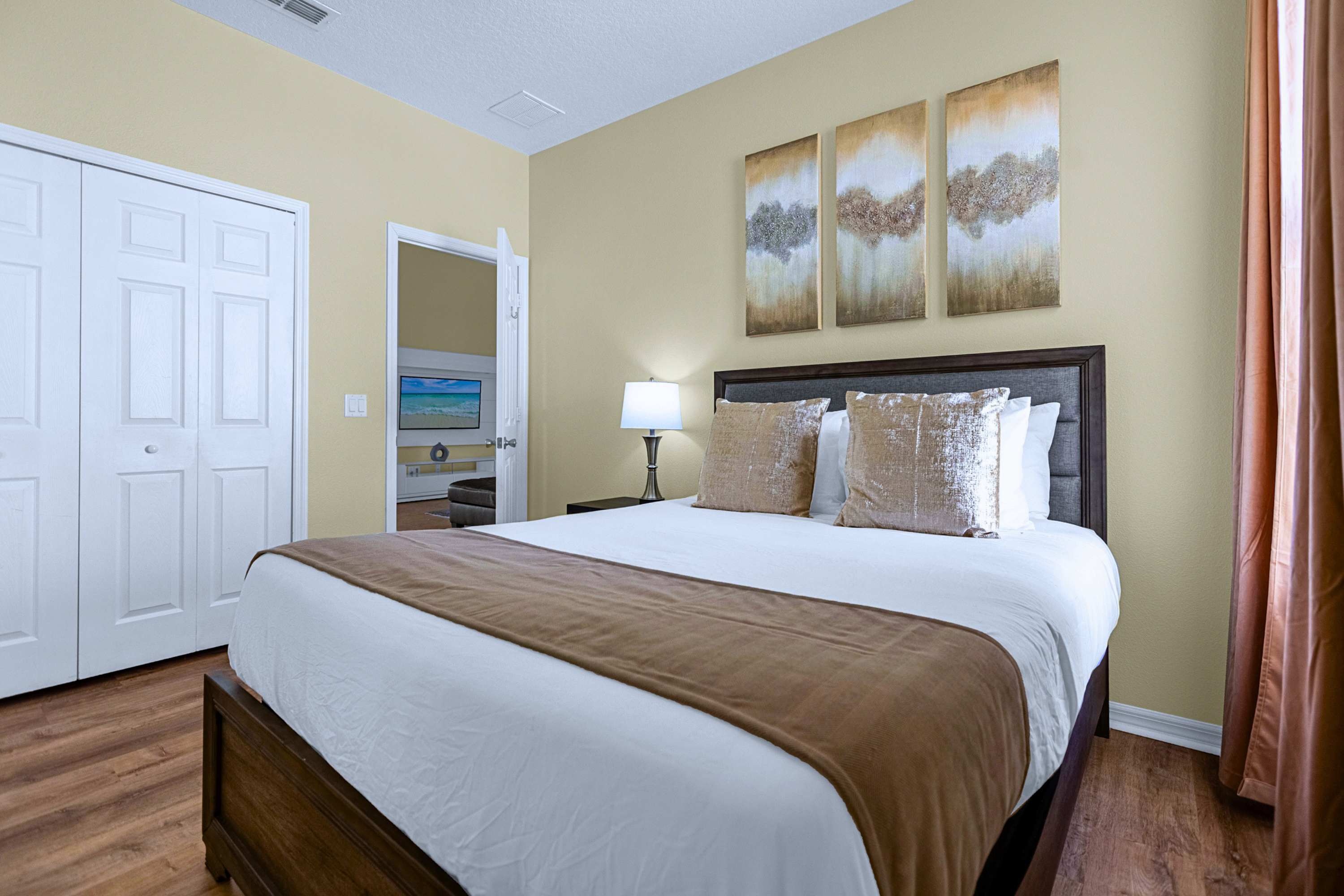 Cozy queen bed with soft linens, bedside reading lamp, and closet access.