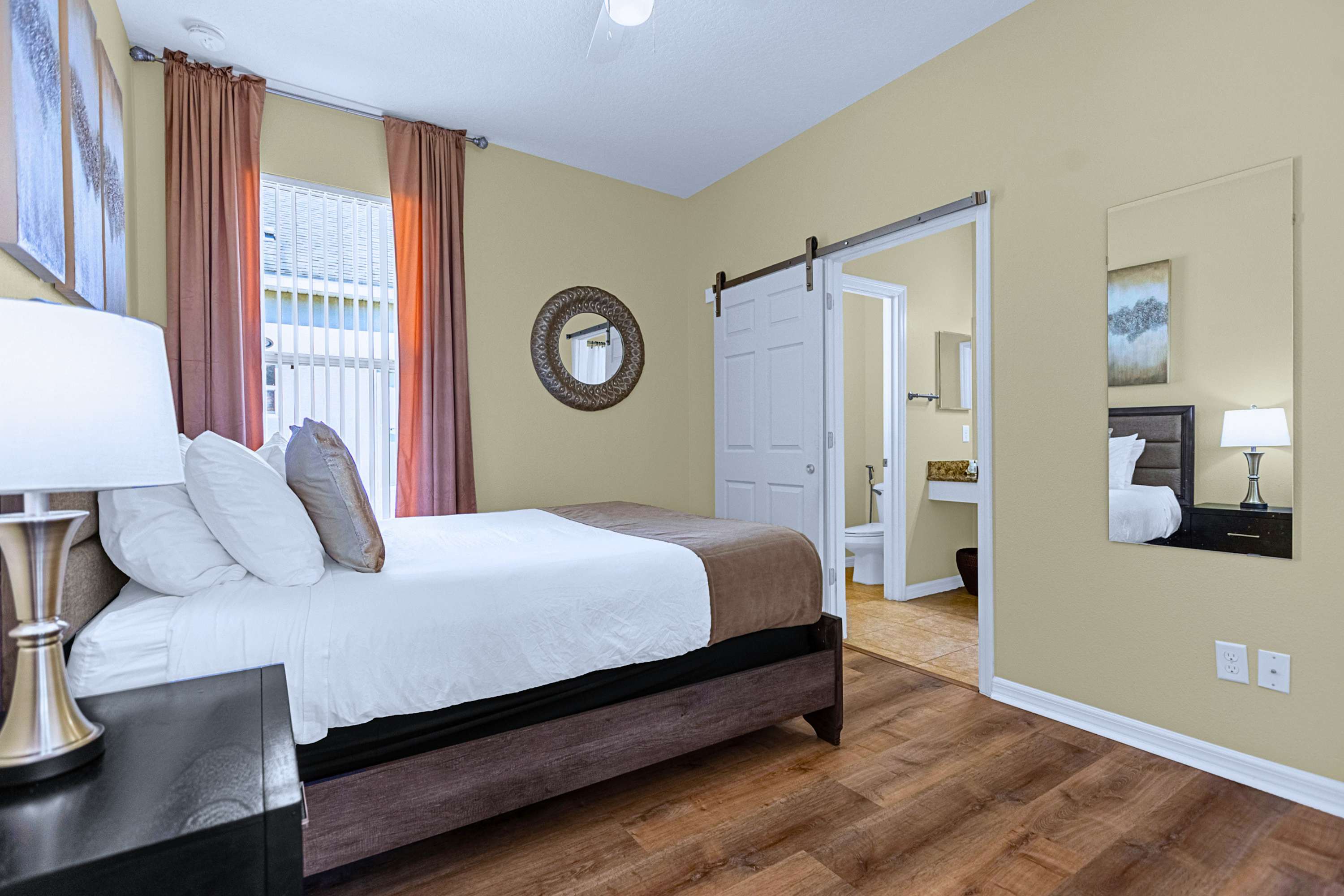 Restful queen bedroom featuring warm side lamps and convenient mirror space