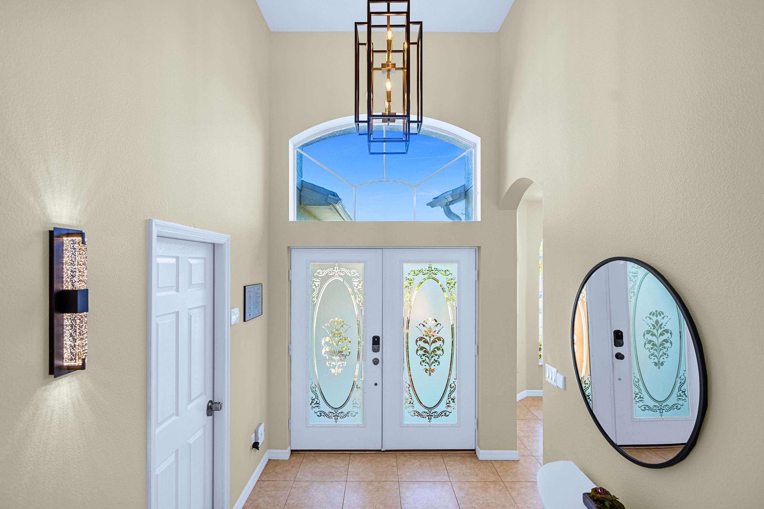 Make a stylish arrival: wide double doors, bright chandelier & vanity mirror.