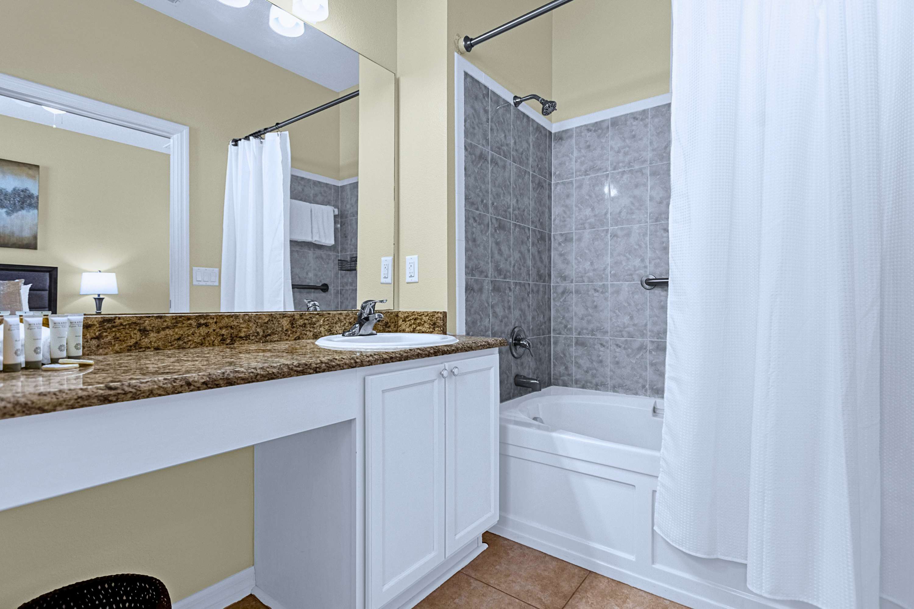 Full ensuite bath complete with vanity mirror, sink, toilet, and tub/shower.