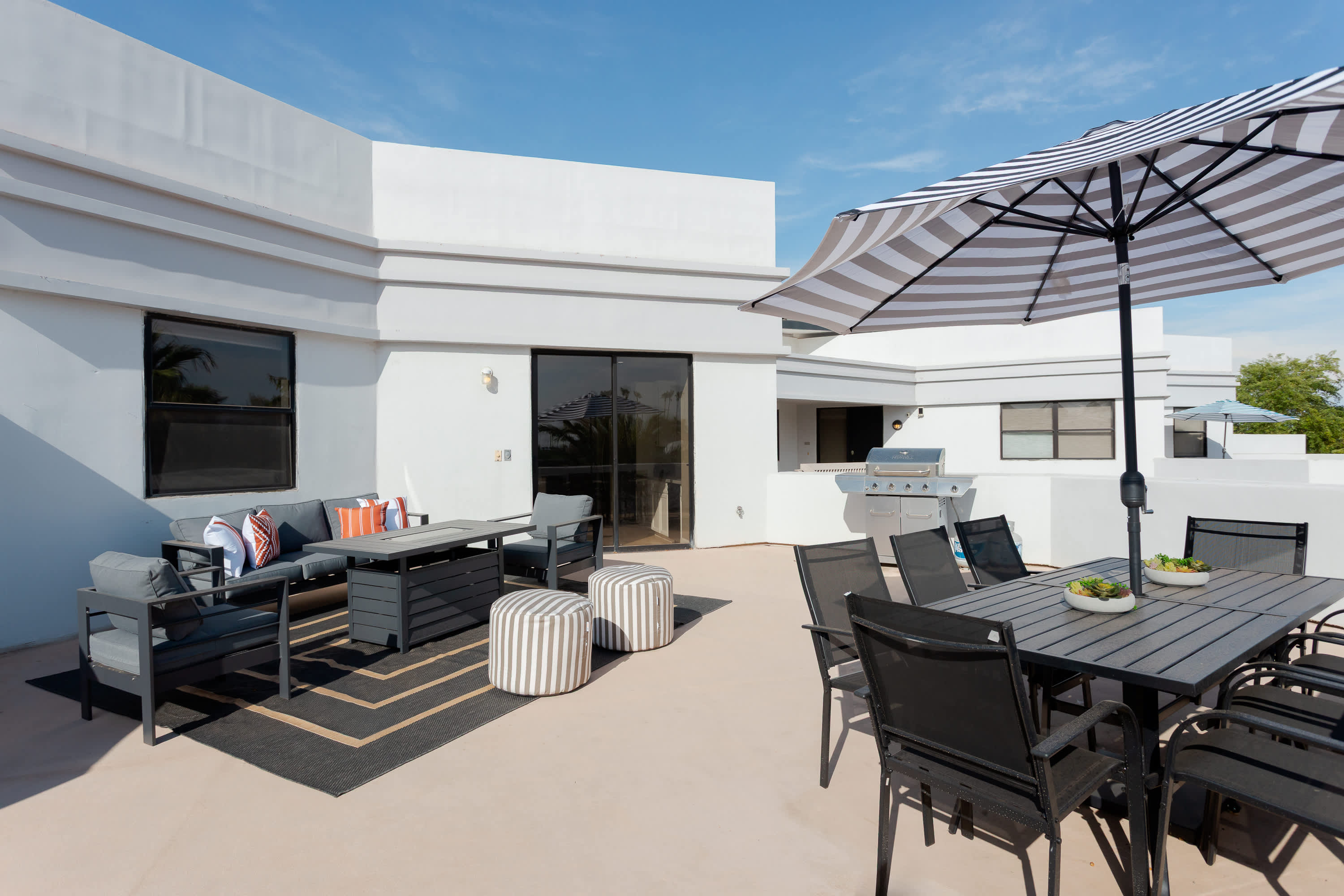 Expansive private balcony featuring lounge seating with built in fire pit table, a BBQ grill, outdoor dining table for 8, and plenty of space to soak up the Scottsdale sunshine or unwind in the fresh desert air.