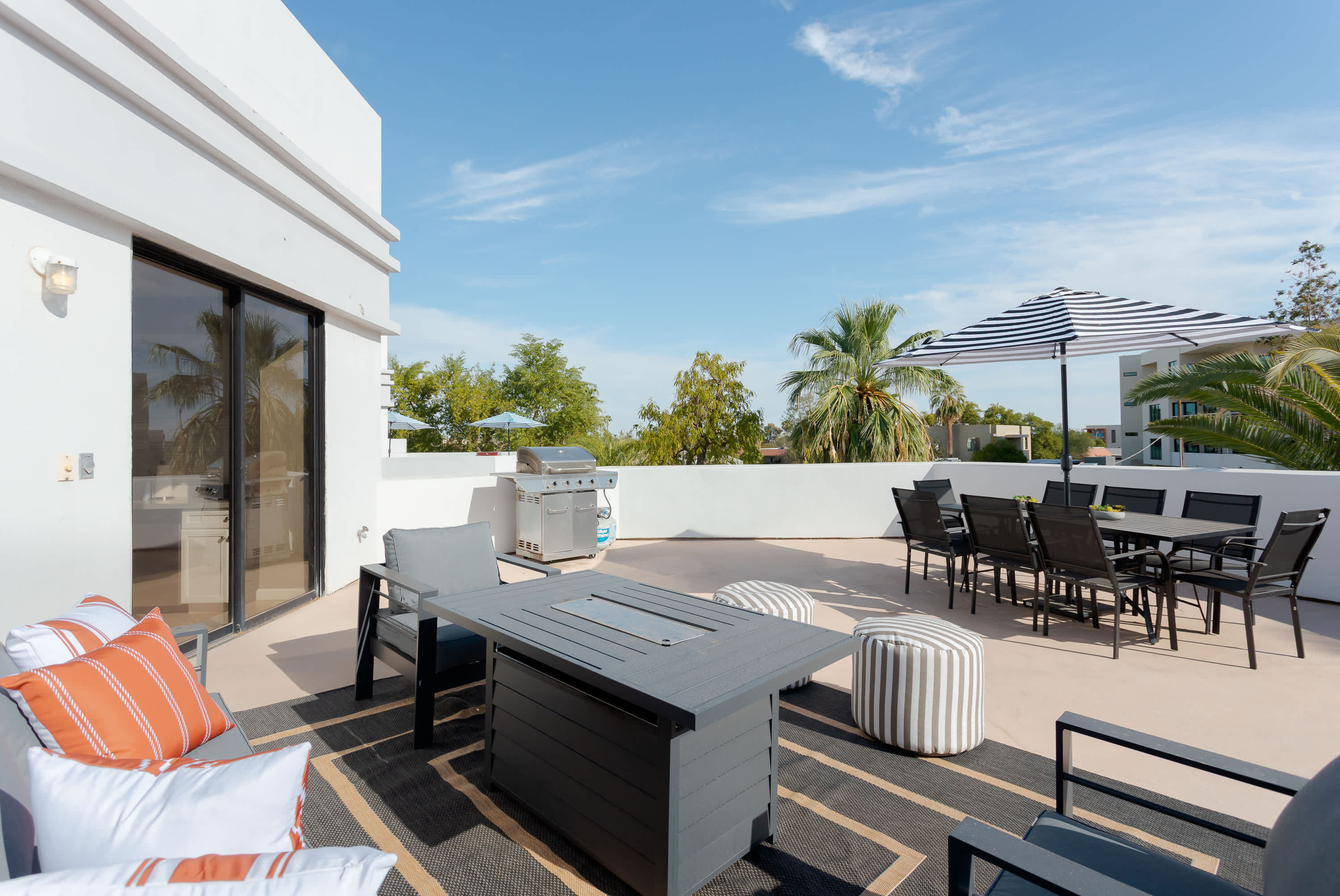 Expansive private balcony featuring lounge seating with built in fire pit table, a BBQ grill, outdoor dining table for 8, and plenty of space to soak up the Scottsdale sunshine or unwind in the fresh desert air.