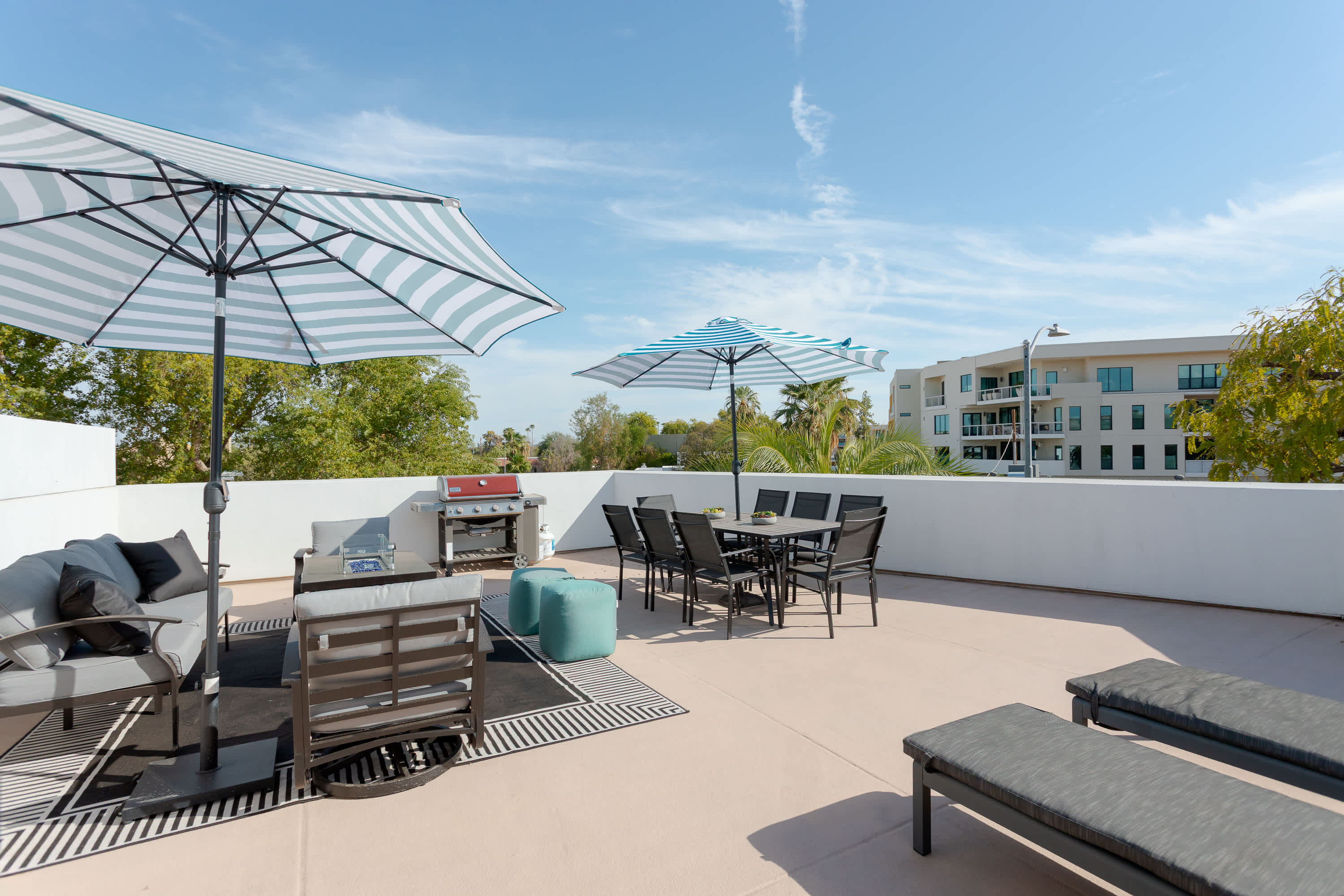 Private balcony with lounge seating with built in fire pit table, a BBQ grill, outdoor dining area for 8, sun loungers, and plenty of room to relax outdoors in the Scottsdale sunshine.