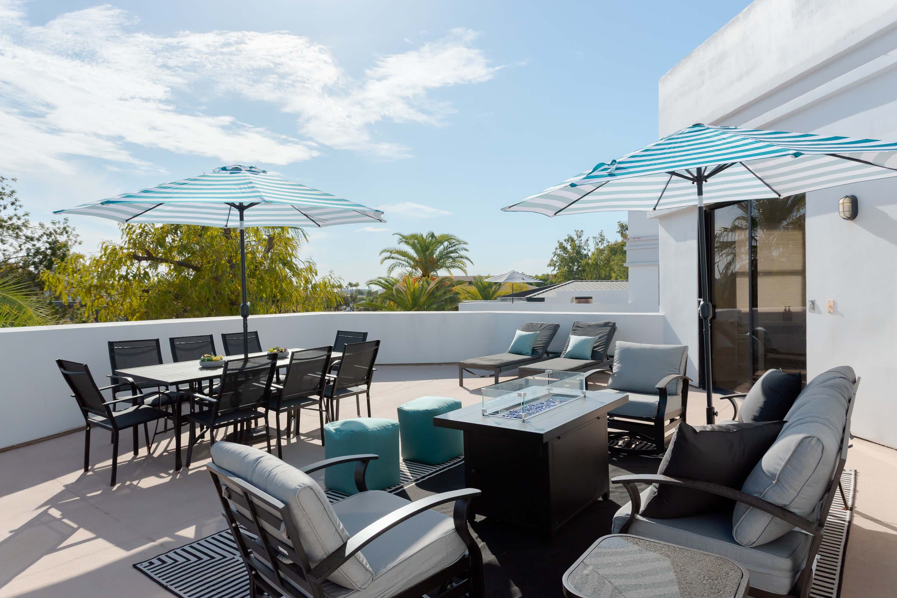 Private balcony with lounge seating with built in fire pit table, a BBQ grill, outdoor dining area for 8, sun loungers, and plenty of room to relax outdoors in the Scottsdale sunshine.
