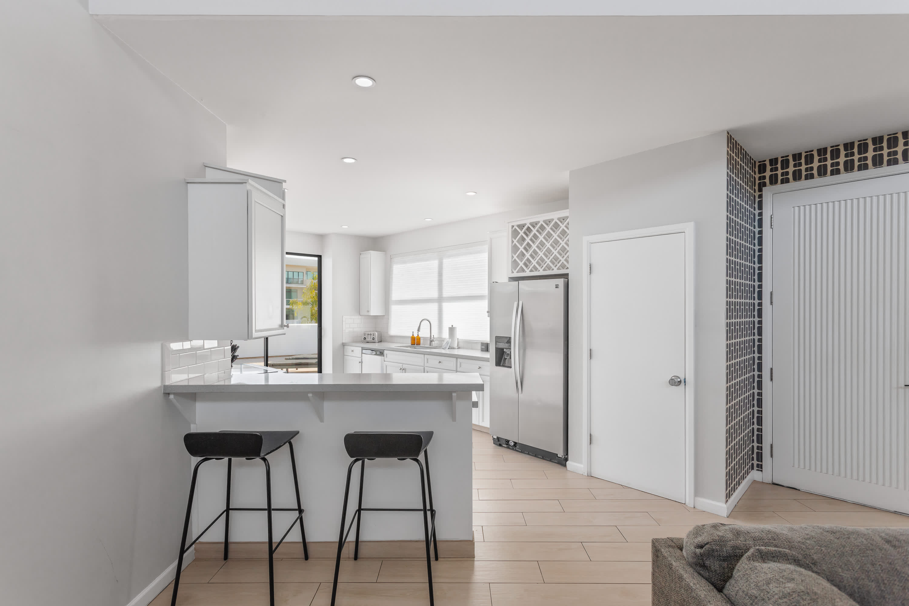 Sleek, well-equipped kitchen with stainless steel appliances, ample prep space, bar seating, and everything you need for meals, snacks, and easy entertaining.