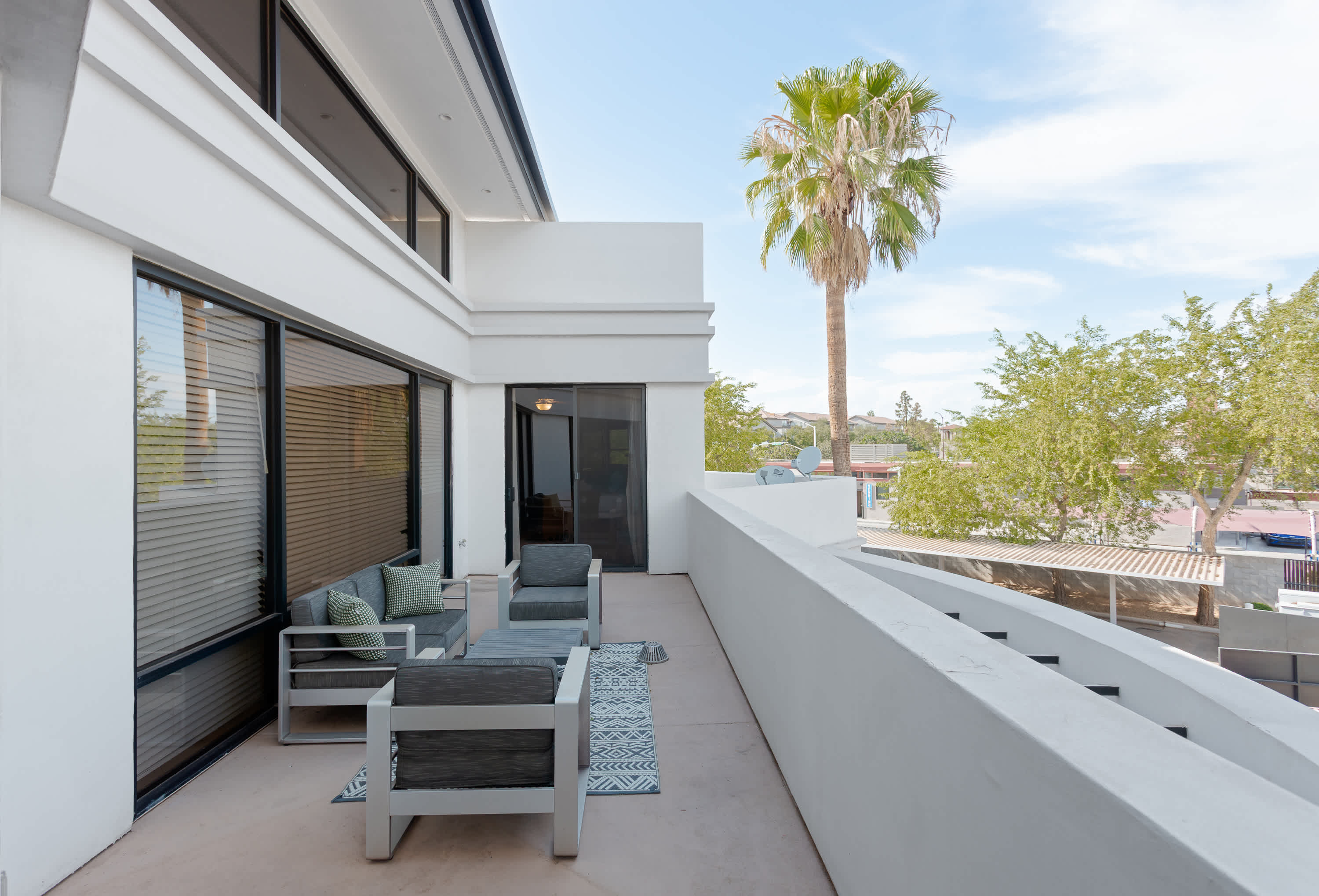 Private balcony off Primary bedroom with comfortable outdoor seating.