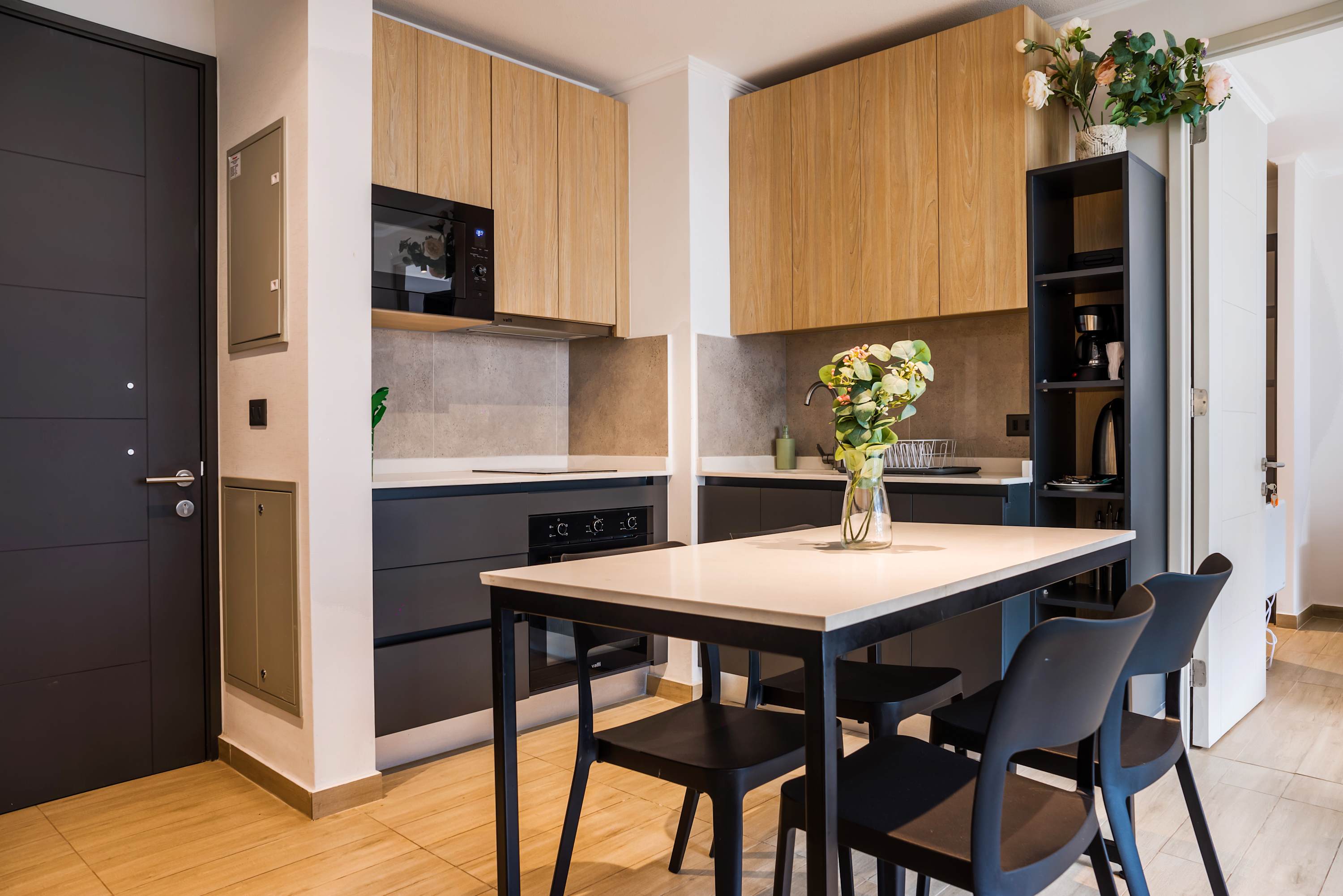 Private kitchen with a generous island, seating for five, modern wood cabinetry, and a built-in microwave for convenient meals at home.