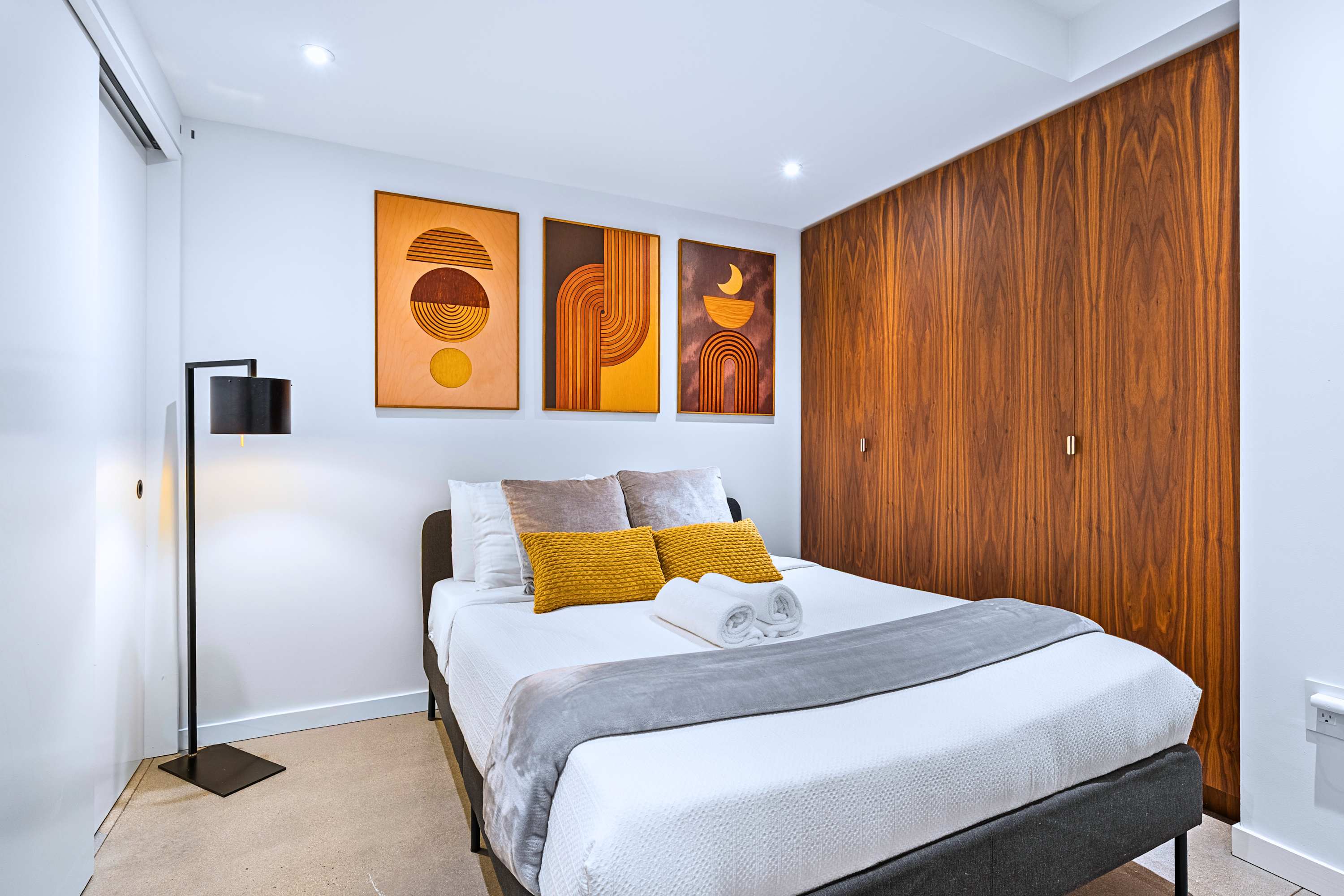 Sophisticated suite fitted with floor-to-ceiling built-ins and plush queen bedding.