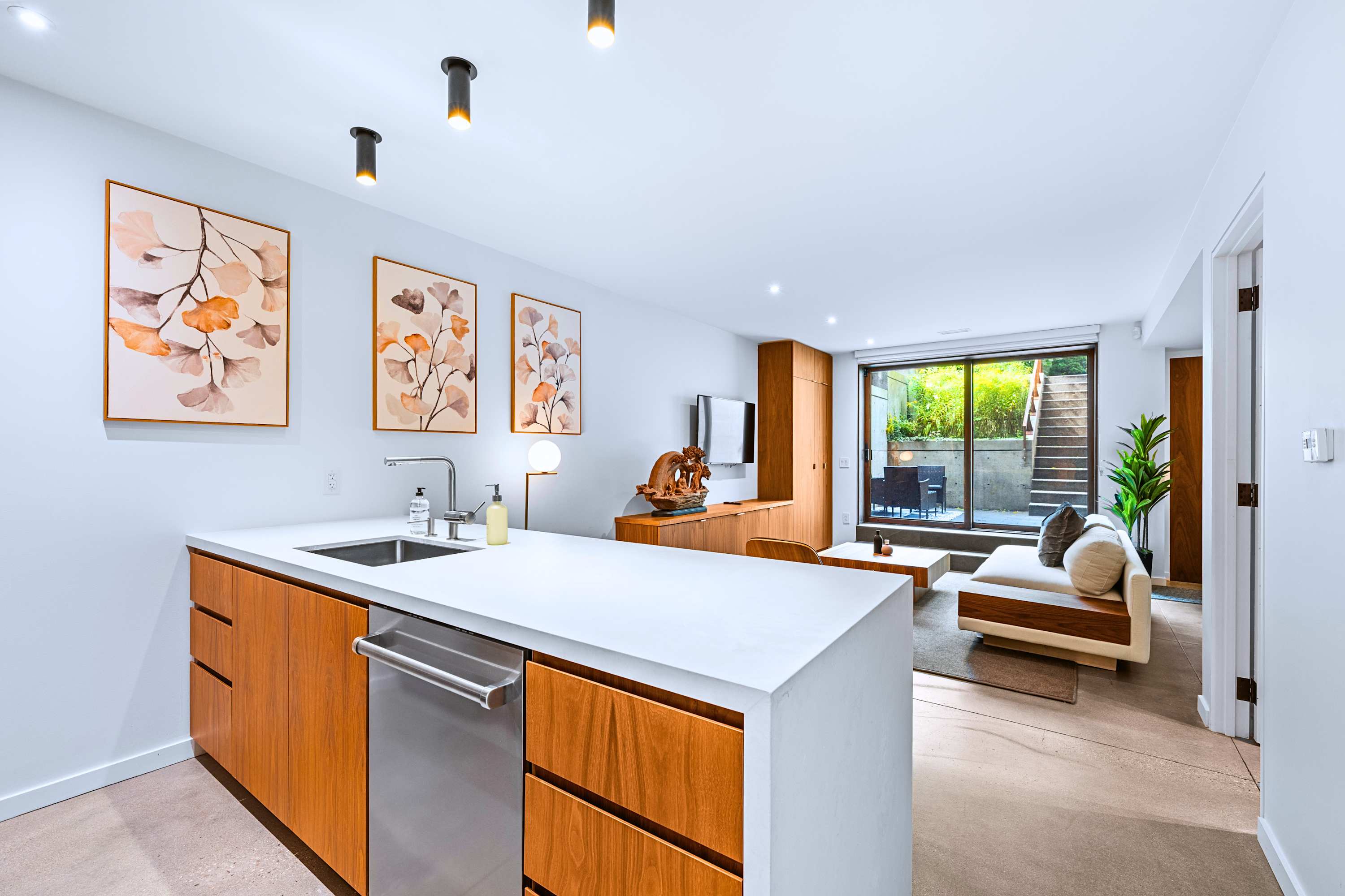 Open-concept stone kitchen island flows effortlessly into a sunlit courtyard living space.