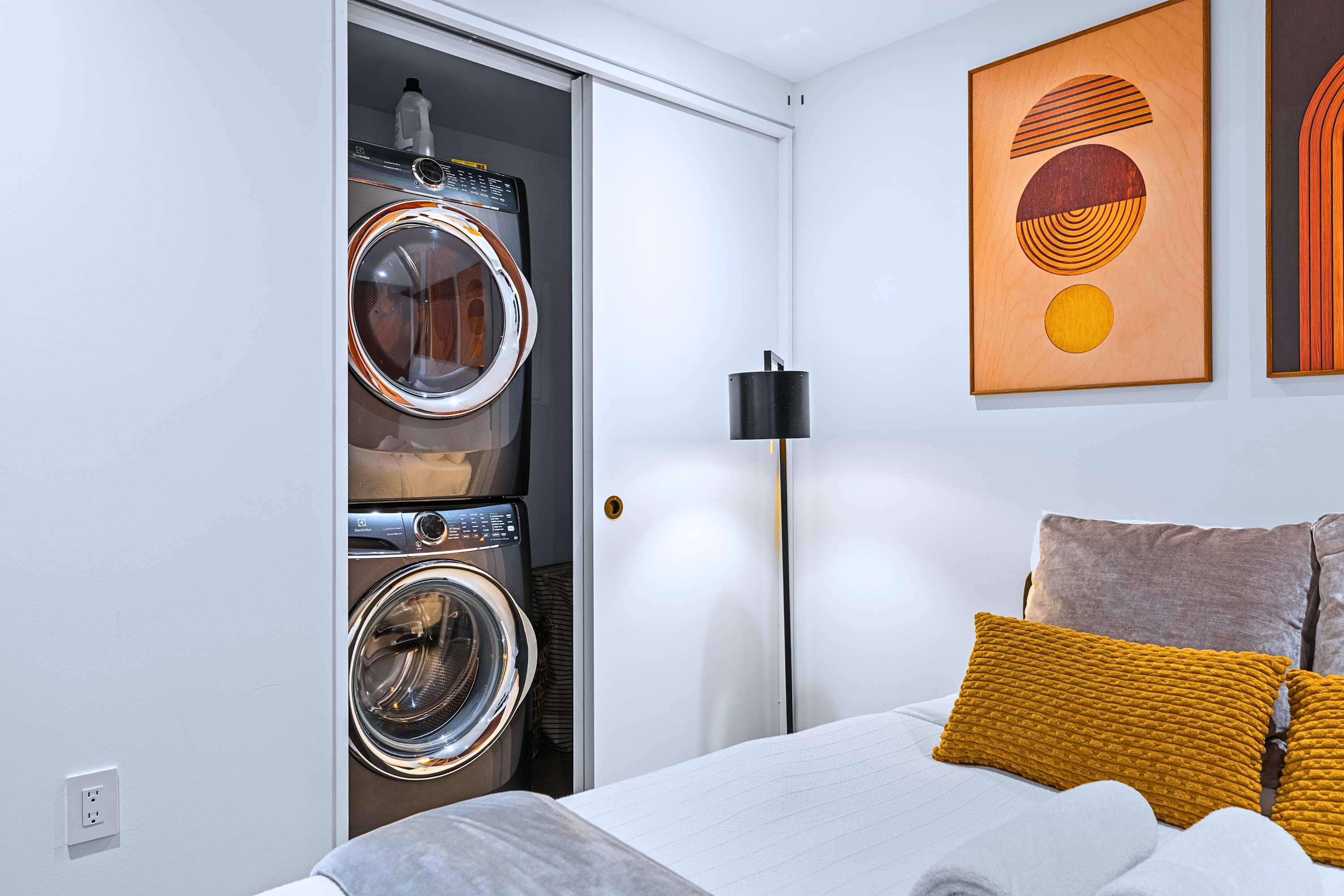 Stacked front-load laundry suite tucked discreetly for convenience on long stays.
