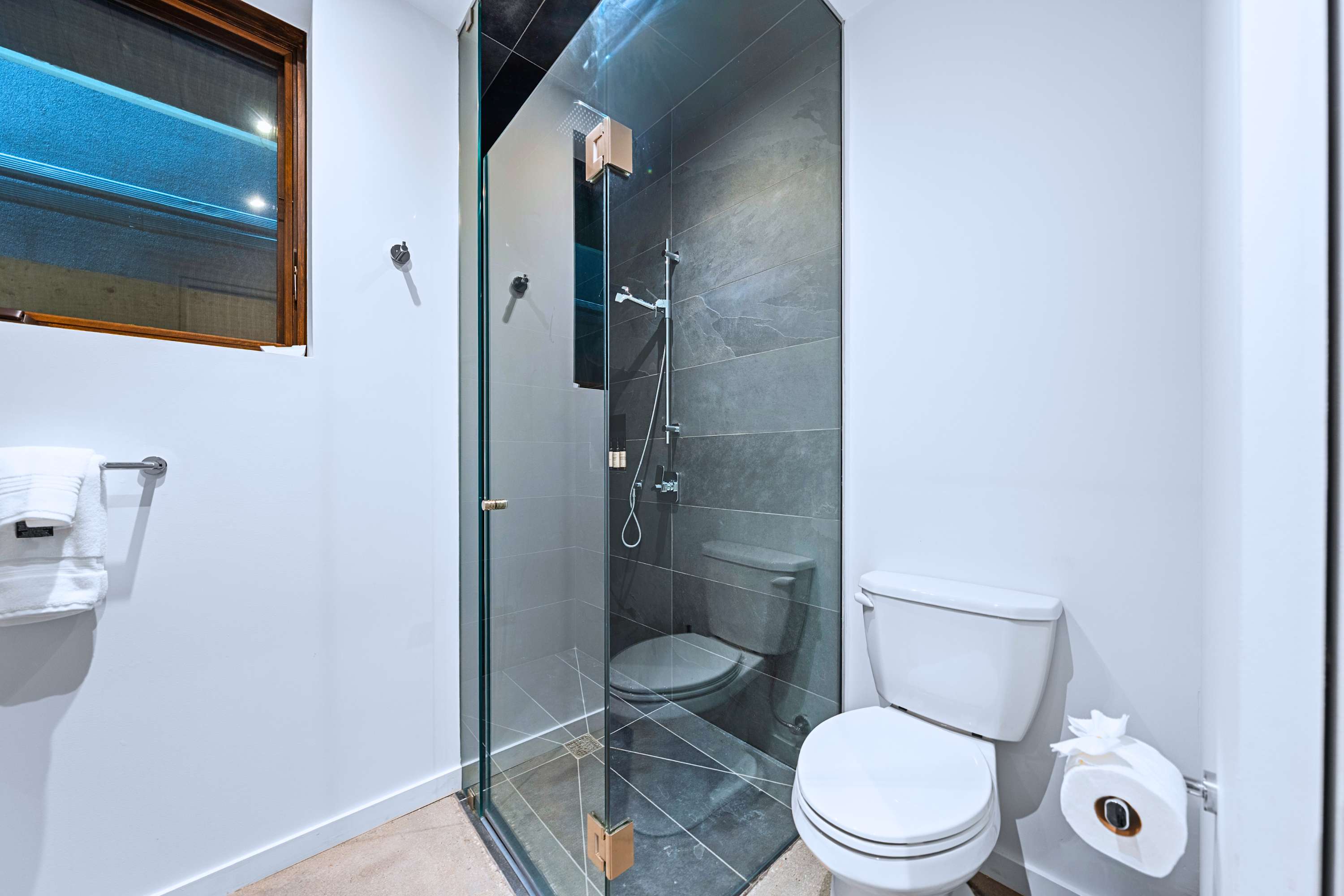 Spa-inspired walk-in shower finished with floor-to-ceiling stone tiles.
