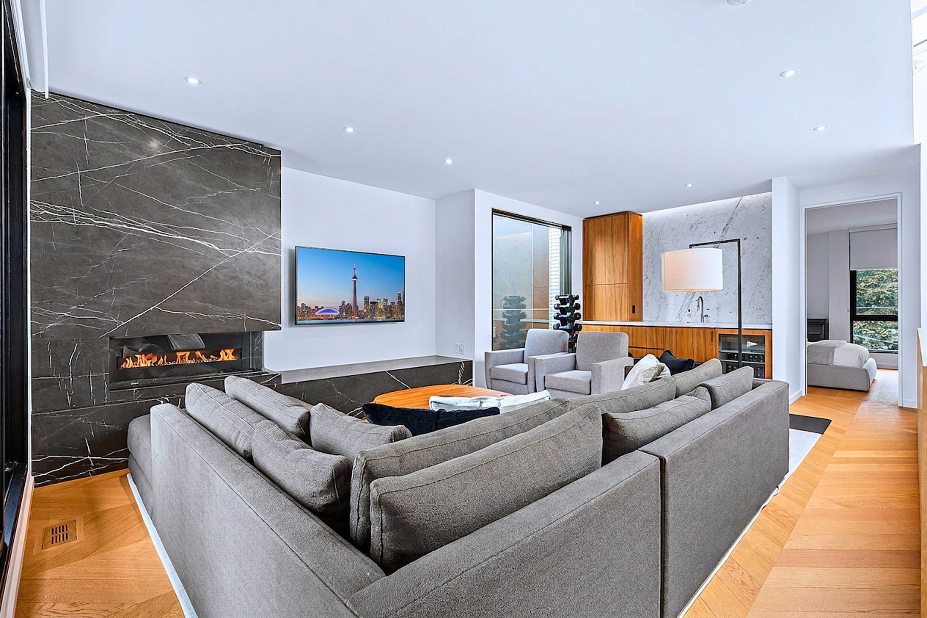 Expansive living zone featuring sectional seating and floor-to-ceiling glass.