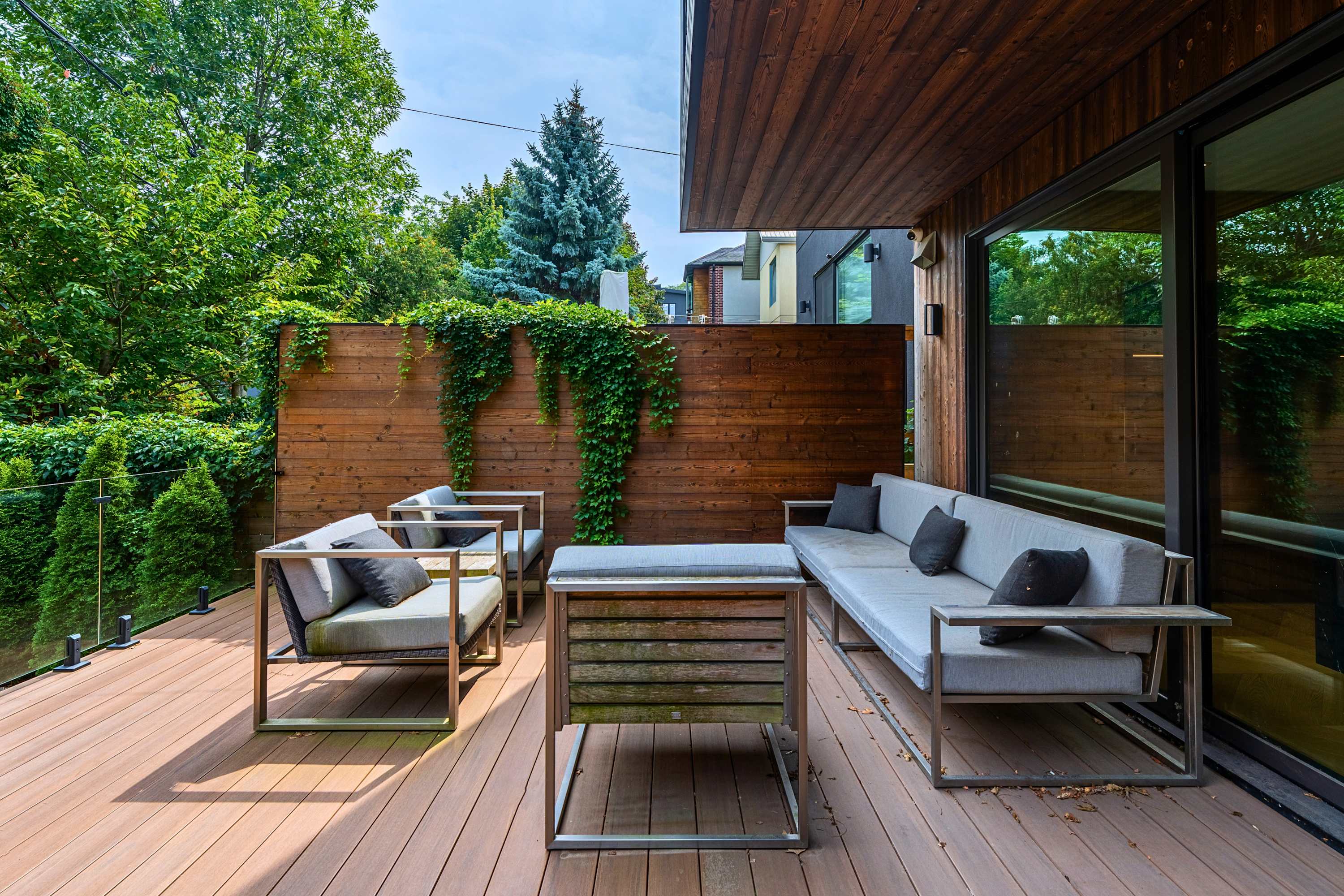 Sunken courtyard patio with cushioned lounge seating and wood privacy fencing.