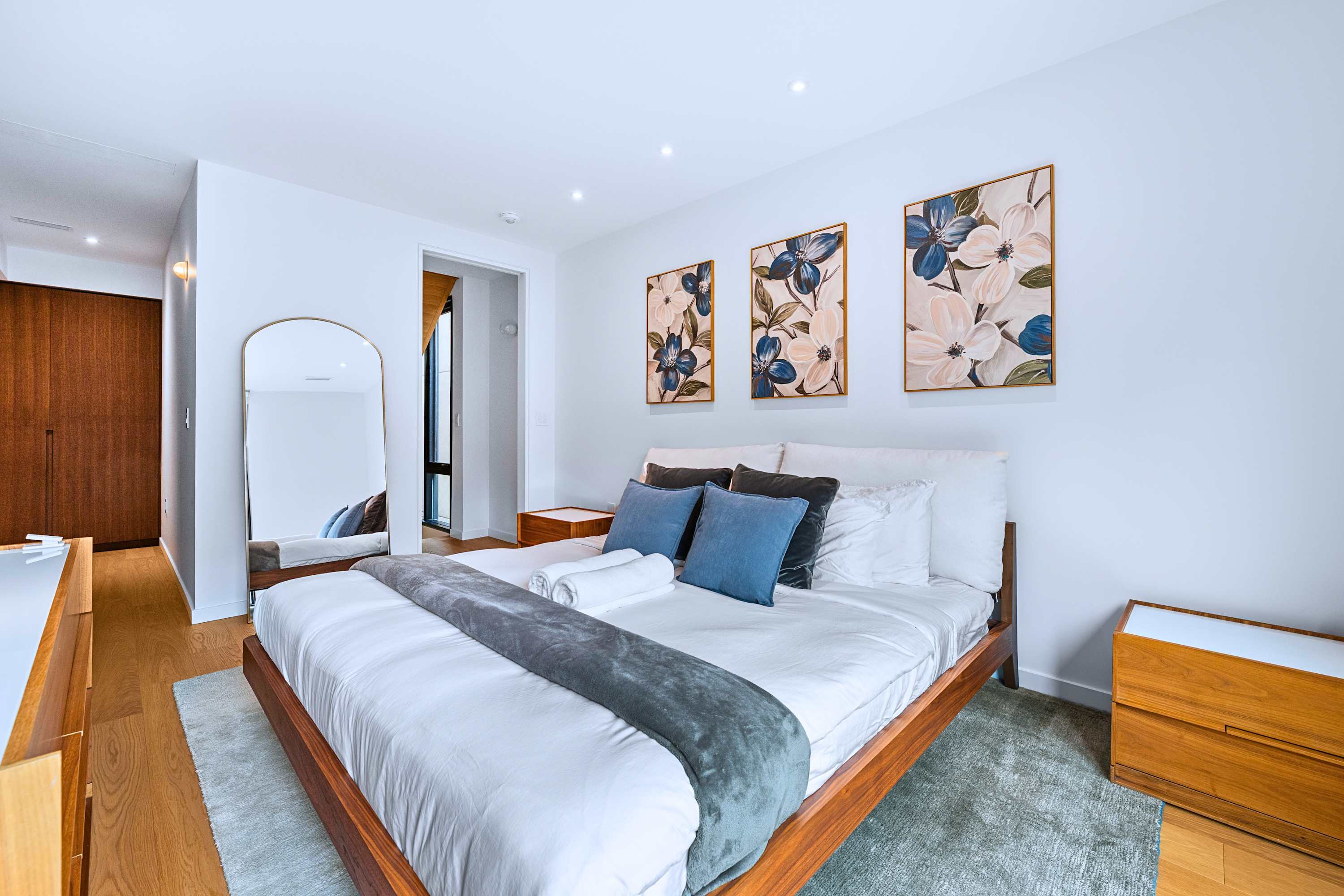 Primary king suite with integrated warm lighting, bedside tables, and hotel-grade linens.