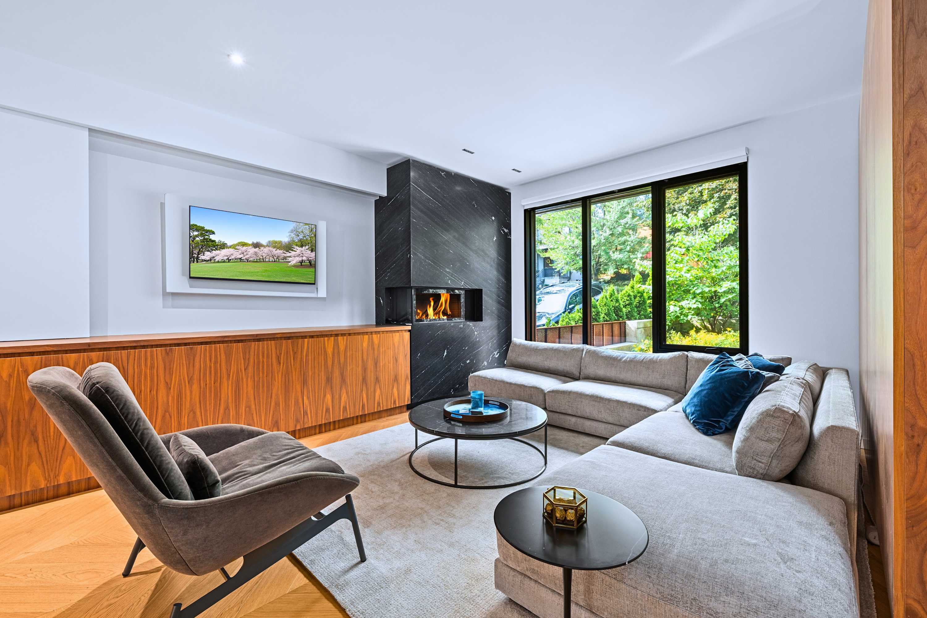 Secondary lounge with fireplace, large windows, and custom built-in storage.